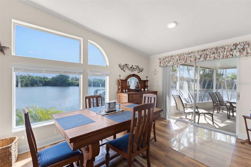 Experience the best of serene coastal living in this beautifully maintained 2-Bedroom, 2-Bath waterfront home, perfectly situated on an exceptionally large 70-ft waterfront lot.  From the moment you enter the spacious foyer, you'll be captivated by the sweeping panoramic views showcased through the oversized windows that frame the tranquil canal and the lush, private mangroves just across the water.  Built in 2000 (furnishings negotiable) this home feels remarkably open and airy thanks to its cathedral ceilings, which enhance the light-filled 1391 sq ft of living space.  Elegant touches such as crown molding and tray ceilings add sophistication throughout.  The seamless flow between the living, dining and kitchen areas creates an inviting atmosphere, while windows on multiple sides bathe the home in natural light from sunrise to sunset.  Two spacious bedrooms provide privacy for residents and guests.  The master bedroom has a large ensuite bath with double sinks, shower, and spacious walk-in closet.  The guest bedroom includes a murphy bed and built in desk area, easily transitioning from office space to a comfortable retreat for visitors.  The 7 X 9 laundry room adds exceptional convenience, complete with washer, dryer, built-in sink, and abundant cabinetry for extra storage.  The expansive lanai overlooks the peaceful canal, a tranquil setting for morning coffee or sunset cocktails.  The 40 ft dock with 10,000 lb boat lift (2000) offers direct access to open water and an easy 20-25 minute ride to Tampa Bay with no bridges.  The 8 X 11 Shed has a work bench and loft for all your seasonal storage. Roof (2023), New foam vapor barrier (2024).  Home is located in Americana Cove, a 55+ community with 24-hr manned gate.  Low HOA $380 includes water, sewer, lawn mowing/edging, trash pickup, heated pool, fitness center, clubhouse, shuffleboard, bocce, and 2 boat ramps.  Many clubs and activities for active lifestyles.  Close to downtown St Petersburg (8 min), 2 airports (20 min) beaches (25 min).  Don't miss this opportunity to live a coastal lifestyle in this beautiful home!