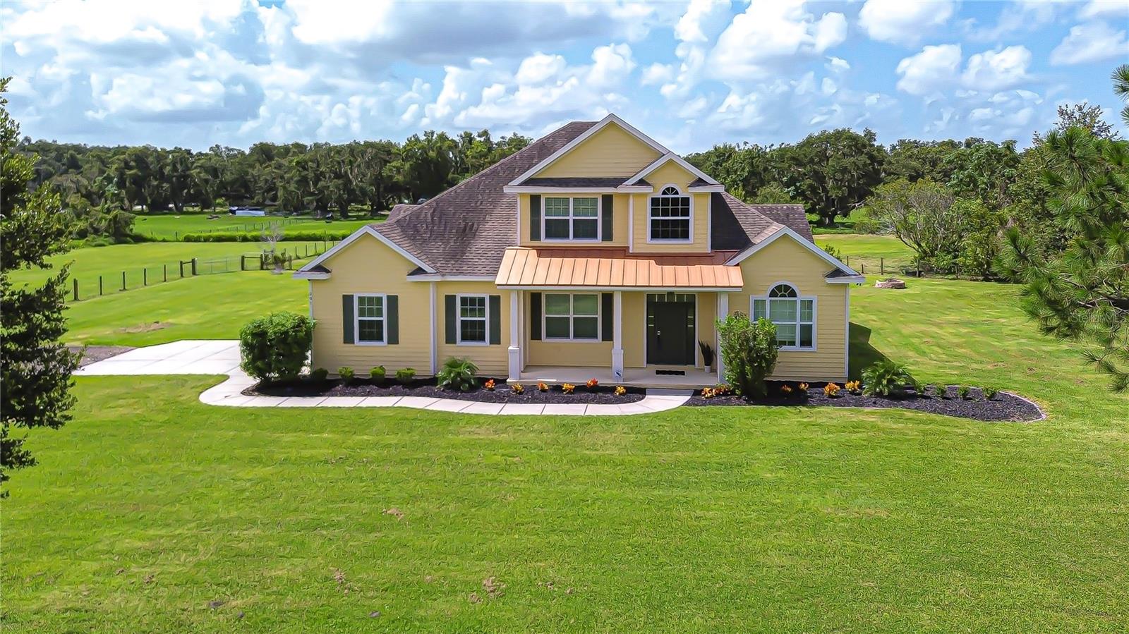 Escape to peace and privacy with this rare and inviting retreat nestled in the heart of Lithia’s scenic landscape, within the highly desirable Newsome School District. This beautifully maintained custom pool home sits on 5.48 fully fenced acres, offering the perfect blend of rustic charm & modern convenience—with no HOA or CDD. Designed for those who love the outdoors & need space to spread out, this property is fully equipped for animals & equestrian use. You’ll find four horse stalls with 30-foot runs, a wash rack, dedicated tack room, working tool shed, & a separate hay and feed shed—a true haven for horse lovers. Two large fenced pastures with new irrigation lines connected to well water provide reliable hydration & healthy grazing for your horses. Two tranquil ponds enhance the natural beauty & usability of the land, whether you're planning a hobby farm, homestead, or peaceful escape. Nature lovers will appreciate being a short walk to Alafia River State Park, with miles of horse trails, hiking paths, and world-class mountain biking—ideal for weekend adventures. Past the gated entry, the main home welcomes you with charming curb appeal, a large front porch, and a warm, timeless elevation. Inside, you'll find fresh interior paint and new luxury vinyl plank flooring throughout the office, dining room, & living areas. The entryway greets you with eye-catching tile inlay, leading to a functional & inviting layout. To your right is a private office with French doors, and to your left, a spacious formal dining room with dry bar. The open living room features soaring two-story ceilings, triple sliding glass doors, dormer lighting, & pre-wired surround sound—creating a bright, airy gathering space. The kitchen is a chef’s dream, with 42-inch custom cabinetry, granite countertops, crown molding, travertine backsplash, & high-end stainless appliances, including an induction cooktop, convection microwave, Bosch dishwasher, and oversized refrigerator. A walk-in pantry & sunny breakfast nook with serene views round out the space. The primary suite offers a peaceful retreat with his & hers walk-in closets, marble countertops, garden tub, & a beautifully tiled walk-in shower. Two additional bedrooms on the main level share a full bath, along with a guest half bath off the main living space for added convenience, while a fourth bedroom upstairs with its own full bath is ideal for guests, a playroom, or home gym. Step outside to your screened-in pool area featuring a pebble tec finish, waterfall, and newer pool pump—perfect for relaxing or entertaining. Throughout the home, you'll find thoughtful details like wood window casings, upgraded fixtures, tile and granite finishes, and a home security system with three cameras. Adding even more value is a separate mobile home on the property—perfect for extended family, rental income, or live-in help. This nearly new unit (just one year old) features its own water purification system, septic tank, & drain field for independent utility service. The additional home offers two bedrooms, two full baths, full kitchen, living room, & laundry hook-ups—ideal for comfortable, self-sufficient living. Whether you're dreaming of a family homestead, equestrian estate, or multi-generational setup, this one-of-a-kind Lithia property offers a peaceful lifestyle with modern amenities—just minutes from top-rated schools, shopping, & major roadways. Copy & paste link to tour home: my.matterport.com/show/?m=yWPz6Z9H2gB&mls=1