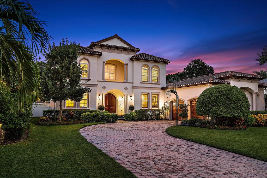 In sought-after Snell Isle, just minutes from vibrant downtown St Petersburg, this magnificent luxury home offers sublime living. The tremendously enviable floor plan features an indulgent master suite and very private office on the first floor and on the second floor, four more bedrooms, each en-suite, while the bright and grand living areas throughout allow for exceptional gathering and entertaining. As you pass through the magnificent 8-foot arched doors, you step into the stunning entry with its soaring ceilings and look through the formal living room out onto the sumptuous pool. The entry transitions into the formal living room with an impressive fireplace, elegant arched and recessed display shelves, and a stunning iron and wood staircase ascending to the second floor. The entry also opens into the gracious dining room, grand enough for your largest dinner party, yet private enough for intimate dinners. The butler's pantry features an under-counter wine cooler, as well as elevated wine storage and display shelves. A special note to wine-lovers here: There is also a built-in floor-to-ceiling wine refrigerator in the house. The butler's pantry leads into the kitchen, and, oh, what a kitchen! Continuing the home's example of exquisite design, this contemporary and dazzling space and has two very large islands with waterfall granite counters, top quality appliances, a huge walk-in pantry, and an informal dining area, which has its own block of built-in cabinets topped by a granite counter. Impressively, this amazing kitchen opens into the expansive great room, which features a ton of light, views onto the garden paradise that is the outdoor living space, and yet another huge bank of cabinets topped with matching granite. This extraordinarily well-designed combination lends itself both to elegant entertaining and inspired day-to-day living, ready to host your best moments and be the setting for years of memories to come. The posh 1st-floor master suite, in a wing of its own, overlooks the tropical splendor of the back yard. The large, private study is purposefully located near the front door, both because this is a quiet part of the home, and because when visitors come to your house for consultation, you can meet with them without their needing to tour the entire home. The back yard is nothing short of a spectacular, private oasis. With a fabulous free-form PebbleTec heated salt-water pool and spa, in-pool cocktail & game tables, all nestled in lush tropical landscaping, it provides the ultimate in outdoor living. At night the pool area and gardens are softly illuminated for you to thrill in the delight of tropical Florida nights. Imagine sitting at a table in the pool watching the game on TV, and for even more fun there is a “party waiting to happen” porch overlooking the pool, complete with a chef's-type stainless grill. With a touch of a button, you can lower or raise the motorized screen to enjoy either an open or screened porch. Garage-lovers will be thrilled here, as well, as the over-sized garage features a ton of extra space. Perhaps store two cars and a golf cart while still having a workshop and toy storage, with additional parking in the spacious drive. The garage is connected to the kitchen by a mud room that also accesses the sizable laundry/crafts room with countertops, sink, and additional storage. A truly fabulous home in an exemplary, first-class location, lacking nothing but its future owners.