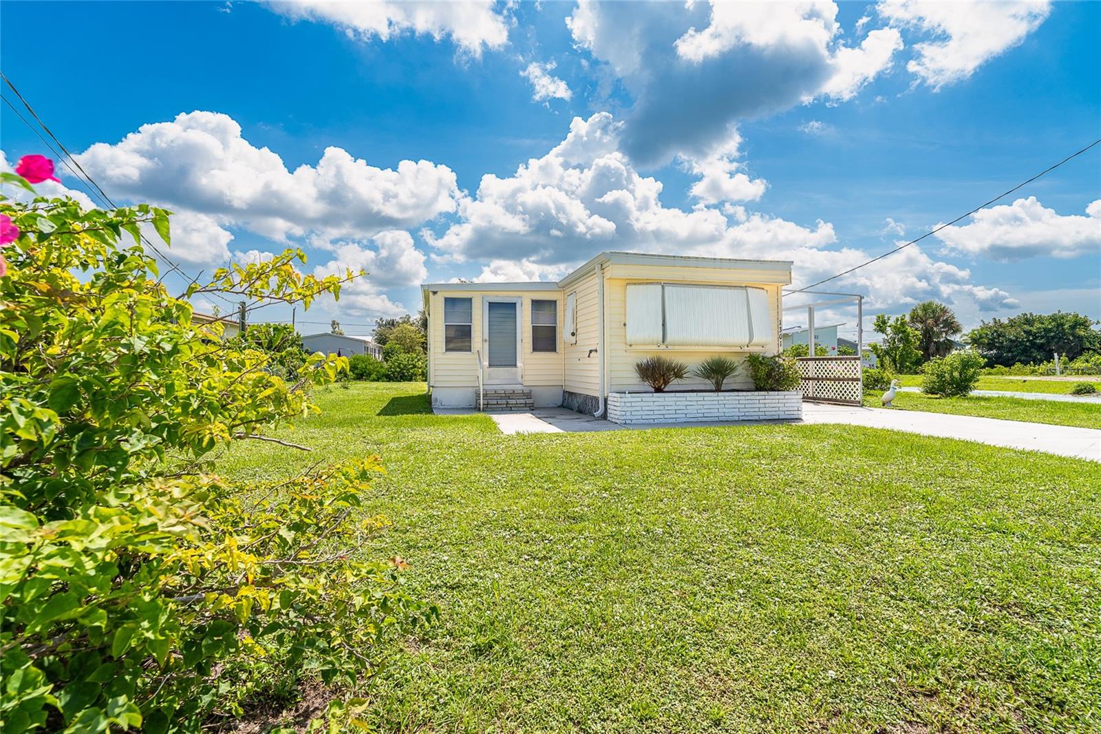 Welcome to Manatee Cove (Holiday Mobile Estates) in beautiful Englewood, Florida! This active 55+ deed-restricted community is pet friendly, golf cart friendly, and best of all—you own the land with no lot fees! Membership to the clubhouse is optional, giving you flexibility to enjoy community activities as you wish.
This charming 2-bedroom, 2-bath SALTWATER CANAL WATERFRONT home offers 880 sq. ft. of living space and is being sold fully furnished—ready for immediate occupancy. Also, nearby are a variety of GOLF COURSES to choose from. With its own private dock, this property is perfect for boating, kayaking, canoeing, or paddleboarding right from your backyard.
The home features a single-wide layout with a bump-out and storage shed, plus a spacious lanai with windows and screens to enjoy year-round. Major updates include: new roof (2023), HVAC (2019), water heater (2022), newer plumbing, and updated electric. The stylish wide-plank vinyl flooring runs throughout, enhancing the open and airy feel.
Inside, the bright and welcoming great room flows into a refreshed kitchen complete with newer cabinetry, sink, fixtures, disposal, two pantries, and 2022 dishwasher and microwave. The split bedroom design provides privacy, with the primary suite overlooking the dock and canal, featuring a generous closet and a beautifully remodeled bath. The guest bedroom also has an en suite bath with newer vanity and toilet.
Step outside through the screened lanai door and onto your own private dock. For boaters, there’s also a community boat ramp nearby (association membership required), providing easy access to Redfish Cove and Lemon Bay.
This waterfront lifestyle comes at a fantastic value—bring your fishing poles and start enjoying sun, fun, and Florida living! All just minutes from shopping, dining, and the beach. Four additional storage closets in the home. Staging items are excluded