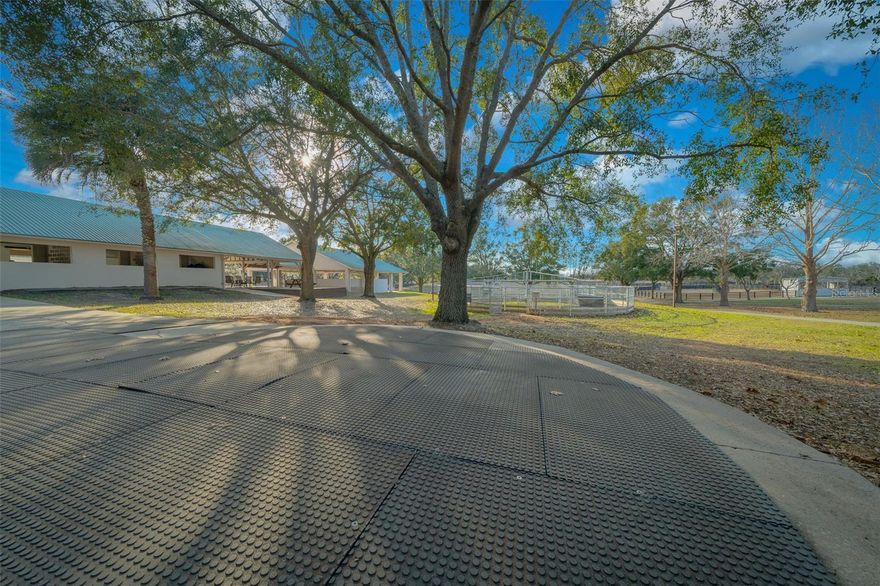 Spanning 16 acres, this picturesque horse farm is a true equestrian paradise. Nestled in rolling hills, it combines functionality with comfort, offering everything needed for horse training, boarding, or private enjoyment. Located in southern Marion County, only 15 minutes from the Florida Horse Park and I-75, 30 min from WEC and close to the Villages. This property is ready to go to work with upgrades including fencing with CenFlex,  2 Concrete Barns with a total of 20 stalls each outfitted with durable rubber mats to enhance horse comfort and safety. Led lighting  Energy-efficient, providing bright and even illumination, commercial-grade fans ensure proper ventilation and air circulation for a healthy barn environment. 4 additional wood barns (two are 12 x 24 and two 12x12) with 6 additional stalls designed for overflow or isolation, creating a total of 26 stalls across all barns. These rustic structures add a touch of charm while still providing practical horse accommodations. Among equestrian amenities are Covered Round Pen with a little sitting area on either side, ideal for observing training or giving lessons in any weather and a Horse Walker for cooling down or low-impact exercise. The 9 paddocks are spacious and well maintained, equipped with automatic waterers, ensuring horses stay hydrated and comfortable. The main barns feature a large, covered entertainment area with a modern outdoor kitchen and top of the line grill and a bathroom. After you’ve entered the property through the long driveway and passed the paddocks you now approach the custom-built home sitting high on a hill, a peaceful and elevated location with sweeping views of the surrounding pastures, creating a tranquil retreat at the heart of the farm. The open and airy 3-bed, 2-bath main home has interior high ceilings throughout with plenty of natural light, vinyl plank flooring, and hardwood floors on all bedrooms and stairs. Its kitchen includes custom cabinets, granite countertops, and a breakfast bar with a built-in wine rack. The Bright and Roomy Master Bedroom features a garden tub, his/her closet, extra-long vanity with double sink. Among improvements to the house within the last 4 years are New metal roof, separate HVAC for the master bedroom on the second floor, new well, pump and tank, gutters, Garage motor with remote control and Water Softener. Schedule your showing today.