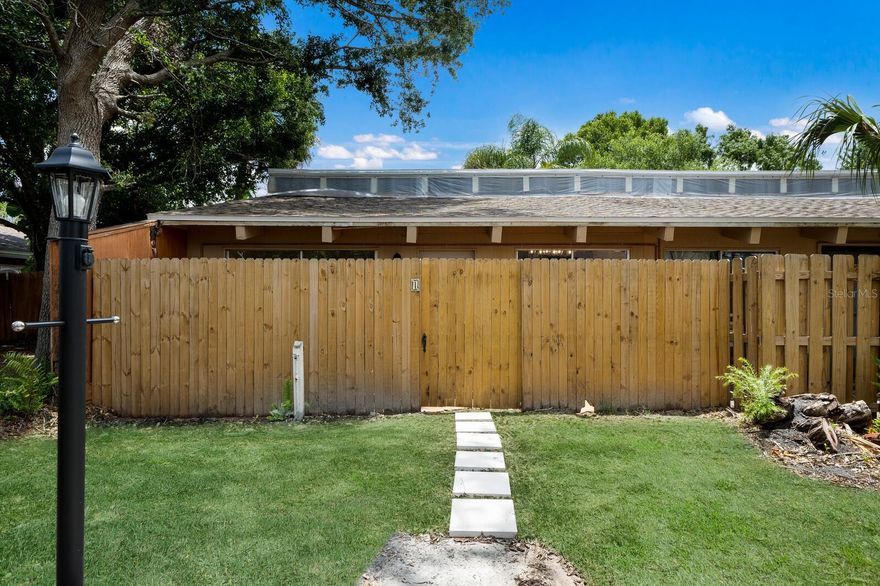 One or more photo(s) has been virtually staged. Just minutes from downtown Sarasota, this beautifully updated end-unit villa offers modern finishes with unbeatable convenience. New roof,  kitchen and new A/C. Step inside to discover vaulted ceilings with skylights, porcelain tile flooring, freshly painted with crown moldings and ceiling fans throughout. A beautifully remodeled kitchen features new lower cabinets, sleek quartz countertops, and brand-new high-end stainless high-steel appliances. The bathroom has been tastefully updated with new flooring, a contemporary vanity, mirror, light fixture, and accessories. Enjoy outdoor living with a spacious front terrace and a private, newly fenced back patio accessible from both bedrooms via sliding glass doors. A brand new A/C unit with 12-yr transferable warranty ensures year-round comfort. The community features a sparkling pool for residents to enjoy, and recent HOA updates include new roofs, rain gutters, and ongoing enhancements to the building exteriors and landscaping. This move-in ready gem is ideal as a full-time residence, winter escape, or investment opportunity just 5 minutes from the heart of downtown Sarasota, with its renowned dining, beaches, arts scene and more.