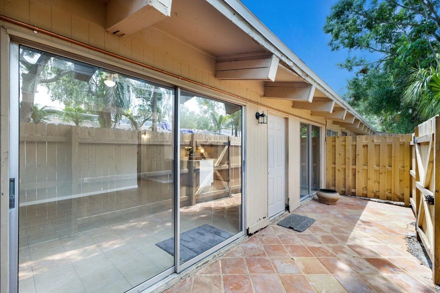 One or more photo(s) has been virtually staged. Just minutes from downtown Sarasota, this cute end-unit villa offers updated finishes with unbeatable convenience. The entire condo complex has new roofs, and this seller has updated the kitchen, bath, appliances and new A/C. Step inside to discover vaulted ceilings with skylights, porcelain tile flooring, freshly painted with crown moldings and ceiling fans throughout. A nicely remodeled kitchen features new lower cabinets, sleek quartz countertops, and brand-new high-end stainless high-steel appliances. The bathroom has been tastefully updated with new flooring, a contemporary vanity, mirror, light fixture, and accessories. Enjoy outdoor living with a spacious front terrace and a private, newly fenced back patio accessible from both bedrooms via sliding glass doors. A brand new A/C unit with 12-yr transferable warranty ensures year-round comfort. The community features a sparkling pool for residents to enjoy, and recent HOA updates include new roofs, rain gutters, and ongoing enhancements to the building exteriors and landscaping. This move-in ready gem is ideal as a full-time residence, winter escape, or investment opportunity just 5 minutes from the heart of downtown Sarasota, with its renowned dining, beaches, arts scene and more. Seller is offering seller-financing at competitive rate and term.