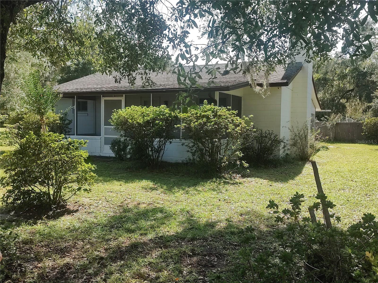 Nearly one acre of land! Enjoy absolute peace and serenity in this quiet country setting. Nestled alongside the Ocala National Forest and within a short drive to The Villages. This home is ideal for someone hoping to purchase an affordable, budget friendly home for their primary residence or weekend getaway retreat or as a lucrative investment property. This charming gem of a home has a fully functional brick fireplace in the living room, covered front and back porch, newer insulated windows throughout the interior of the home, newer electrical panel, detached garage for parking, storage or projects. There is an additional garage space for covered and secured boat storage. The lot is nearly one acre and features mature landscaping, complete with fruit trees. The yard is large and impressive with lots of room for gardening or adding additional improvements. The community offers the residents a fishing pier at Lake Catherine, with direct access to stunning, picturesque views and ideal for kayaking, fishing, or simply enjoying the peaceful lake views. This oversized parcel of land tucked away in a quiet country setting is an incredible opportunity at a fantastic price.