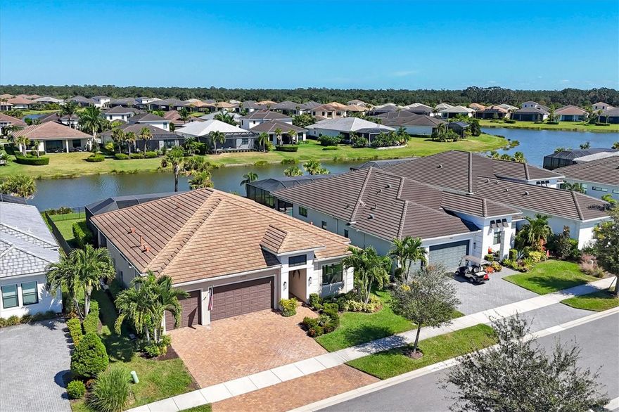 Luxury meets value in Artistry Sarasota! This beautifully designed 2-bedroom plus den, 2-bath home sits on a premium waterfront homesite while offering quality, style, and comfort in one of Sarasota's premier gated communities. Step inside to an inviting open layout filled with natural light. The bright, modern kitchen features white cabinetry, quartz countertops, a 36" gas cooktop, and a wall oven, all open to the dining area and great room with peaceful lake views. Elegant electric shades in the living and dining areas provide effortless comfort and privacy at the touch of a button. The den off the foyer makes an ideal home office or creative retreat, while the owner's suite impresses with coffered ceilings, a dual-sink quartz vanity, and a frameless glass-enclosed shower with bench. Enjoy Florida living at its finest on the extended covered lanai, complete with an outdoor kitchen, electric sun shade and sparkling saltwater pool perfect for relaxing or entertaining while taking in tranquil water views. The fenced yard is a great bonus for pets. Artistry Sarasota is a natural gas, maintenance-free community offering neighborhood amenities including a clubhouse, fitness center, pool, playground, pickleball and basketball court, plus easy access to Lakewood Ranch, downtown Sarasota, and the Gulf beaches.