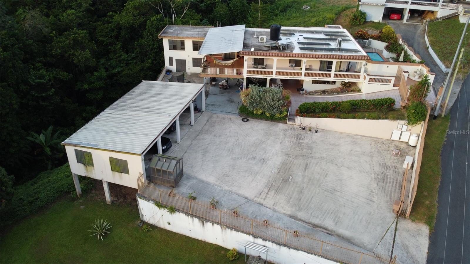Exceptional Multi-Unit Property with Complete Energy Independence
A rare opportunity to own a completely self-sufficient compound featuring three distinct living spaces, cutting-edge renewable energy systems, and luxury amenities.
Main Residence (1,362 sq ft)
This thoughtfully designed main house offers comfortable living with 3 bedrooms and 2 full bathrooms, plus 2 convenient half bathrooms. The heart of the home features a well-appointed kitchen and spacious living room, complemented by a dedicated office space and generous walk-in closet. Entertainment flows seamlessly with a custom bar area, while practical needs are met with a dedicated laundry room. Step outside to your private swimming pool for ultimate relaxation.
Lower House - Entertainment Haven
Perfect for hosting and recreation, this versatile space includes a full kitchen, half bathroom, and stylish bar area with expansive entertainment space. The impressive 5-car covered parking ensures ample vehicle protection, while the attached greenhouse offers endless possibilities for gardening enthusiasts.
Self-Contained Apartment
Ideal for guests, rental income, or multi-generational living, this complete apartment features 1 bedroom, 1 bathroom, full kitchen, comfortable living room, private laundry room, and convenient tool room for storage and projects.
Unmatched Energy Independence & Infrastructure
This property represents the pinnacle of sustainable living with:
• 31 solar panels providing abundant renewable energy
• 2 Tesla Powerwall batteries for seamless energy storage
• Automatic transfer switch ensuring uninterrupted power
• 100-gallon propane tank for backup fuel needs
• Solar water heater for efficient hot water
• 600-gallon cistern with water purification system
• Backup generator for ultimate security
• Complete appliance package: 2 washers, 2 dryers, 1 freezer, 3 refrigerators
• Climate control: 5 air conditioning units throughout
• Pool maintenance: Professional-grade pump and filtration system
Investment & Lifestyle Benefits
• Multiple income potential with three separate living spaces
• Virtually eliminate utility costs with comprehensive solar system
• Complete water independence and purification
• Extensive storage and workspace options
• Perfect for extended families or investment opportunities
• Hurricane/disaster preparedness with backup systems
This extraordinary property offers the unique combination of luxury living, environmental consciousness, and financial independence. Whether you’re seeking a primary residence, investment property, or sustainable lifestyle compound, this turnkey opportunity delivers unparalleled value and peace of mind.PR-164, Km. 12.4, Lot “A” , Palmarejo Ward, Corozal, P.R,. 00783