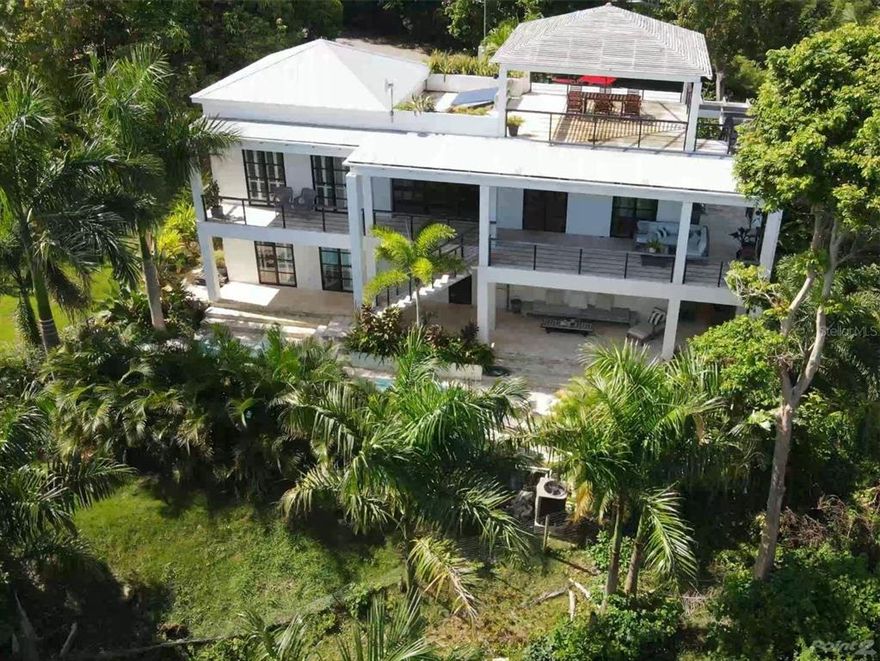 This chic and modern villa is located in Puntas Rincon, on a dreamy, quiet dead-end road, in one of Rincon’s finest barrios. Distinctly original and immaculate, it is a magical tropical paradise, designed by award-winning Boston architect (Flavin Architects) and built-in 2018. Villa Piña was designed to be a minimal, peaceful environment that perfectly blends luxury indoor/ outdoor Caribbean living.
Villa Piña has custom built details in every room to make this home beautiful and special. Wood, glass, poured concrete details, high ceilings and a hint of rustic charm make the space an absolute pleasure to be in.
Lush, mature landscaping surrounds the property. The gardens are especially gorgeous around the 40-foot saltwater lap pool.
Take in the water view stretching from Aguadilla Bay to the northwest from every room on the main floor.  Walk up to the finished roof deck and enjoy the panoramic water view. Open the custom garage doors in the dining room and dine al fresco with views. The custom-built gourmet kitchen, chef designed, has a poured concrete sink, concrete countertops and a concrete island topped with stainless steel.   
There are multiple outdoor living spaces surrounding the house with built in lounging areas.
This extremely unique villa has 3 bedrooms with the space for an additional one, 2 full baths, 1 half bath, and 2 additional outdoor showers.
Live your best life here surrounded by light, water, and tropical nature. 5 minutes from all surf breaks and beaches.
Property land square meters:-2010.79 m2 - Indoor space square footage:-2400 sq ft - Outdoor living space square footage:-Main and lower floor covered patios- 1200 sq ft   - Roof Deck - 420 sq ft 
Salt water 40 ft lap pool – temp controlled
Custom kitchen:
Beautiful views from kitchen windows. Stainless steel countertop. Custom Birch hand sandblasted cabinets. Custom poured concrete islands and sinks. Floating shelves and custom pantry - Gas stove - Dishwasher
Bedrooms:
3 Bedrooms with space for an additional bedroom
Bathrooms: 2 full bathrooms -One half bath - 2 outdoor showers
Custom oversized concrete poured double sinks in the full bathrooms as well as tiled bathroom floors.
The master bathroom shower is a beautifully designed outdoor area.
All concrete floors inside-  All Coralina tile decks outside
Multiple luxury, covered, outdoor seating areas with custom built-in lounger and Imbuia wood accents Imbuia wood and steel porch roofs and railings. Large roof deck- perfect for a large dinner party or yoga session with friends
2 Custom garage door walls in the dining room open to create a completely open space.
Sunrise views, sunset color.

Three power sources:
Full solar array and 2 Tesla Powerwall Batteries - 22KW Generac Generator - Hooked up to the power grid - Solar hot water heater - 5000-gallon built in water cistern - Triple filtered water system

Ceiling lights and sconces from Schoolhouse Electric - Haiku fans in every room throughout the house, and 2 located under front porch
A/C in each bedroom  - Huge basement, laundry room with sink, owners’ closet, lots of storage
Custom designed and handmade driftwood hooks, hat racks, mirrors, and other accessories, custom made Imbuia wood surfboard rack

Property:
Strong rental income history- Airbnb income details upon request- all 5-star reviews, a Superhost property.
Potential for use as a wellness retreat space, a luxury event space, or a corporate accommodation space.