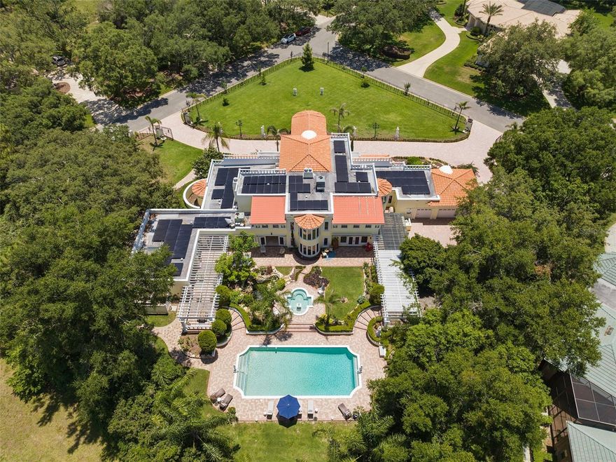 Welcome to Villa Limone, a luxurious estate in the prestigious 24 hour gated Sweetwater Club neighborhood. This architectural masterpiece sits on a 1.15-acre corner lot, blending classic European elegance with modern sophistication. With 7577 square feet of impeccable design, this home showcases marble Italian statues, crown molding, arched doorways, coffered ceilings, wainscoting, and exquisite flooring throughout. The property is fully secured with an 8-foot iron fence, electric gates, and features a grand double genuine "Heroic Starburst" front door. Inside, the majestic foyer with triple crown molding, cement columns, and a custom-built library sets the tone for the exceptional craftsmanship found throughout. The living room impresses with soaring ceilings, Italian crystal chandeliers (worth $15,000), and a double-sided fireplace and double staircases. Additionally, there is a separate guest house with a full kitchen, and private entry, providing a comfortable space for extra guests to relax and enjoy their stay. The gourmet kitchen is a culinary enthusiast's dream, equipped with top-of-the-line Thermidor and sub-zero appliances, custom cabinetry, and two large islands. A stunning dining room offers the perfect ambiance for formal dinner parties, featuring another magnificent chandelier, fireplace, crown molding, wainscoting, and coffered ceilings. The sunroom hallway seamlessly connects the indoors with the beautifully landscaped outdoor living spaces with doors that open fully for those cooler days. The master suite is a private oasis with a sitting area, fireplace, laundry area, dressing rooms, spa-like en-suite bathroom, and a walkout roof deck. Additional double bedrooms with connecting bathrooms ensure ample accommodation for family and guests. The landscaped grounds feature imported Italian statues, fruit trees, water fountains, dog run, and a serene Koi pond with waterfalls. The outdoor entertainment area boasts a saltwater swimming pool, hot tub, sauna, outdoor kitchen, and 2 pergola-covered patios. This smart home offers Lutron light switches, a hydra-wise irrigation system, and clock. Recent updates include master bath ,a new roof, solar panels, ( bringing electric bill down to about $70 per month ) HVAC systems, custom built library, hot water tanks, and a generator. Located near Wekiwa State Park, natural springs, with easy access to Route 4 and nearby amenities, this home holds a rich history as it was built by the Toblerone chocolate family and previously owned by a prominent figure from Boar's Head Meats. Experience the charm and prestige of this one-of-a-kind estate in Longwood's sought-after neighborhood. Contact us today for a virtual or in-person showing at your convenience.