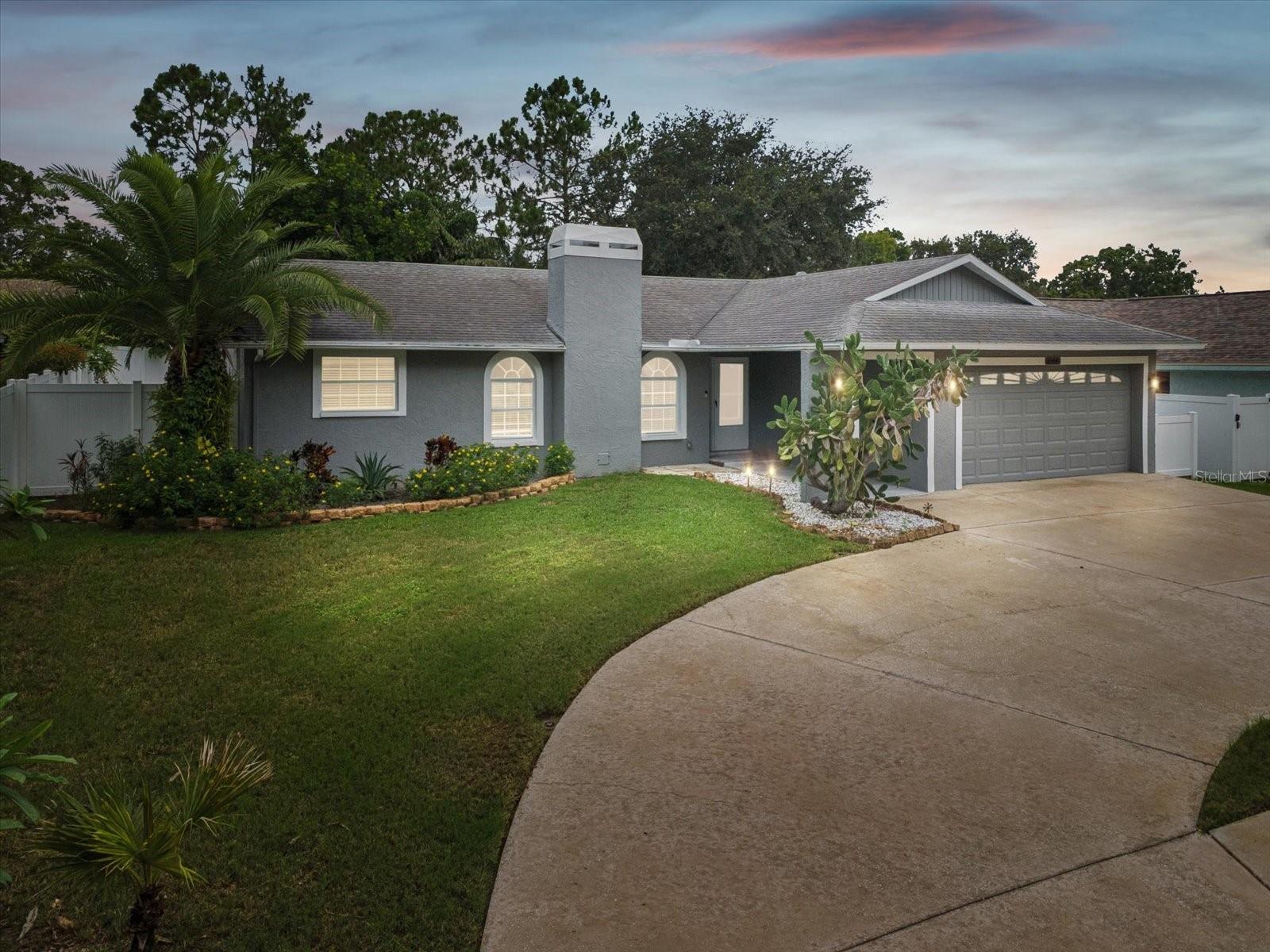 Experience the perfect blend of style, comfort, and Florida living in this charming 4-bedroom, 2-bath home in the desirable Hidden Lakes community of Palm Harbor. Just a short walk from Palm Harbor High School, this home offers an ideal setting for families and entertaining alike. A circular driveway and vinyl fenced yard welcome you, complemented by vibrant landscaping, an irrigation system, and a thoughtful layout that provides both privacy and curb appeal. Inside, ceramic tile flows throughout, creating a seamless backdrop for the open and inviting spaces. The great room features a cozy wood-burning fireplace, ceiling fan, and abundant natural light, while the dining area features French doors to the pool area, making indoor-outdoor entertaining effortless. The kitchen is a chefs delight with a raised L-shaped seating area, quartz counters, ceramic tile backsplash, range cooktop, stainless-steel fridge, dishwasher, oven and an oversized pantry. A convenient pass-through window connects to the covered poolside porch, perfect for hosting summer gatherings! The adjacent laundry area includes the washer and dryer. The master suite offers a peaceful retreat with dual mirrored closets with custom built-ins, ceiling fan, and French doors that open directly to the pool area, creating a seamless connection between indoor comfort and outdoor living. The en suite bathroom features an extended quartz vanity and walk-in shower with a sliding glass door. Three additional bedrooms provide flexibility for family, guests, or home office space, each with ceiling fans, ample closets, and access to outdoor areas in two of the bedrooms. The secondary bathroom offers a double sink complemented by marble accents on the walls and shower, a tub/shower combination, providing both style and functionality for family or guests. Step outside to your private backyard retreat, featuring an inground chlorine pool with an extended paver patio, all enclosed within a protective Bird Cage for safety and privacy. The covered back porch with a ceiling fan provides a shaded space for relaxing or entertaining, while the poolside layout creates an inviting setting for summer gatherings, quiet afternoons, or evening swims. With thoughtful upgrades, abundant living space, and a location that combines convenience with tranquility, this home is ready to welcome its next chapter. Discover your ideal Palm Harbor lifestyle in Hidden Lakes today!
