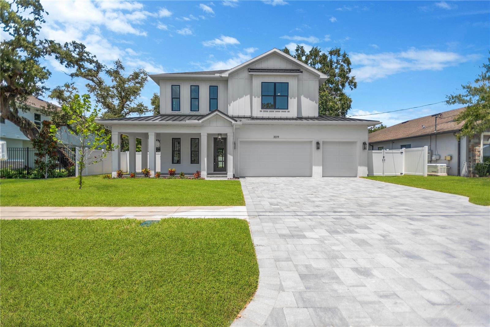 Move-in ready new construction in a prime South Tampa location! This beautifully designed 5-bedroom, 4-bathroom home with a 3-car garage offers 3,025 sq. ft. of luxurious living space, with large covered lanai over looking expansive backyard on a oversized lot (70x118) with plenty of room for a pool. Showcasing timeless curb appeal, the home features a charming wrap-around front porch, paver driveway, St Augustine sod with irrigation system, vinyl fencing and elegant architectural details. Inside, you’ll find 10’ ceilings and 8’ doors on both levels, Impact hurricane windows, Trane HVAC system, smooth finish drywall, wide-plank engineered hardwood flooring throughout (tile in wet areas), drop zone with cubbies, built in closets and tray ceilings with integrated lighting. The open-concept main living area includes a built-in electric fireplace, dining room, and a designer kitchen with shaker-style cabinets to the ceiling, quartz countertops, GE stainless steel appliances, an electric cooktop, built-in oven/microwave combo, and a spacious walk-in pantry. A first-floor bedroom or office and a full bath with shower add flexibility and function to the main level. Upstairs, the expansive primary suite offers dual walk-in closets and a spa-inspired bath with a freestanding soaking tub, frameless glass shower, double vanity, and private water closet. The second floor also features a large en-suite bedroom with a walk-in closet, two additional bedrooms sharing a full bath, a loft with a built-in wet bar and mini fridge, and a well-appointed laundry room with custom cabinetry, quartz counters, and a sink.