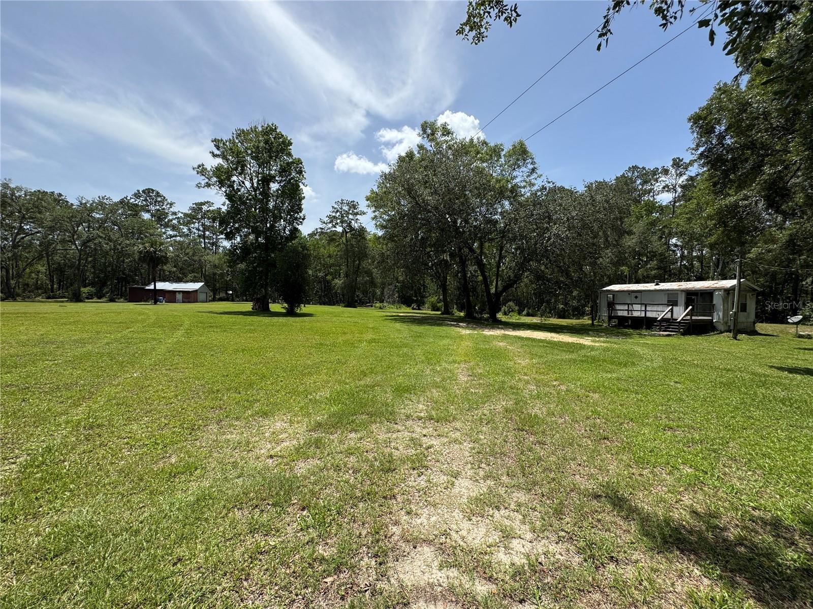 Motivated seller! This beautiful secluded 4.11 acres Zoned A1 has a 1 bedroom and 1 bath mobile home with a HUGE workshop 50x25 building with overhead roll-up door and attached 15x13 office. This is the perfect place to build your dream compound. It has a long driveway to from the main road to give you peace of mind and privacy. Close to WEC, HITS, Publix, Walmart, hospitals and many more amenities. No deed restrictions. Has power, private well and septic.