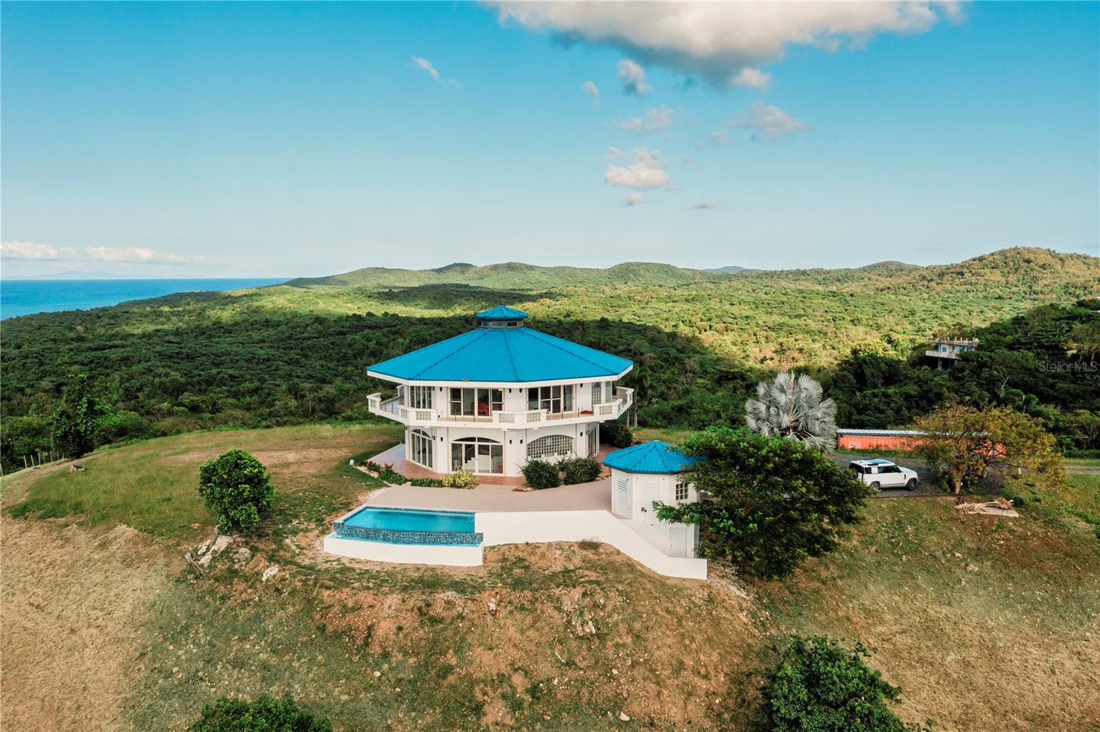 Nestled within five glorious, tropical acres, this exceptional estate on Vieques Island offers a once-in-a-lifetime opportunity to experience unparalleled luxury and tranquility. Beyond it's gated entrance, a world of serenity awaits, where panoramic vistas and unparalleled privacy create an oasis unlike any other.
The centerpiece of this remarkable property is the stunning main house boasting three bedrooms spread across over 3200 indoor square feet of meticulously designed living space. Using Mahogany and Yellow Cyprus throughout the home creates a wonderful organic and sophisticated atmosphere from rich textures to warm tones and natural, timeless beauty. The oversized primary bedroom is pure luxury with front row views of the magnificent Caribbean sea and is inclusive of an office, bedroom and sitting room, bathroom and balconies. All three bedrooms offer mini-split air conditioning. With high ceilings and an abundance of natural light, every corner of the main house exudes an air of sophistication and elegance. Additionally there are over 2000 square feet of covered terraces offering 360 degree views of Vieques Island and beyond including Culebra Island, St. Thomas, St. Johns, the main island of Puerto Rico, Vieques Island's North Coast including the break water known as Rompeolas and thousands of acres of Fish and Wildlife Nature Preserve.
The expansive terraces provide the perfect setting for outdoor, tropical entertaining or quiet, serene relaxation, offering breathtaking views including stunning sunrises and sunsets. Imagine sipping cocktails with close friends as the sky transforms into a canvas of vibrant colors, or unwinding in solitude while the cooling breeze whispers through the palm trees.
For guests seeking their own slice of paradise, a charming guest house awaits, offering a private pool side retreat complete with a bedroom and bathroom of 500 square feet. Whether hosting visitors or seeking a quiet sanctuary , the guest house is the epitome of island retreat.
A brand new infinity-edge swimming pool and expansive pool terraces beckons residents to immerse themselves in luxury, with a beach area perfect for lounge chairs where one can soak up the Caribbean sun in style. Surrounded by tropical landscaping, the pool area has quickly become the newest haven on the property for relaxation and rejuvenation.
From every vantage point, panoramic views stretch as far as the eye can see, offering a glimpse into the natural beauty of Vieques Island. Whether admiring the rugged coastline, the stunning natural Wildlife Preserve, or sparkling azure waters, each vista is more breathtaking than the last.
Experience the magic of Vieques Island from the comfort of this truly one-of-a-kind luxury estate, where unparalleled ocean views and seclusion are the premier focus of this extraordinary home representing the pinnacle of the Caribbean lifestyle.