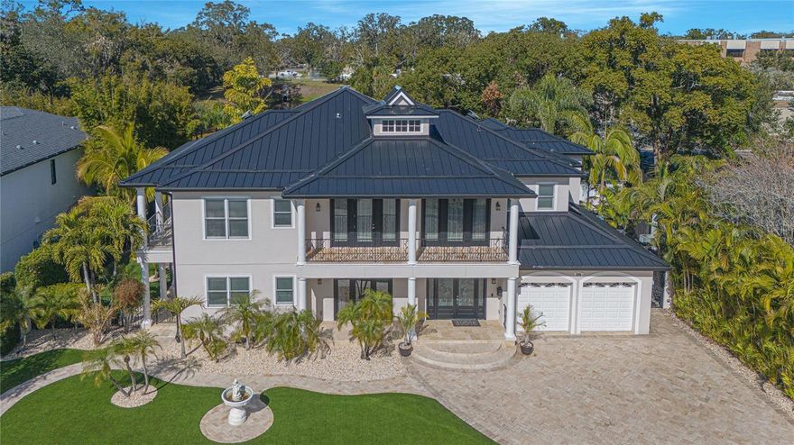 Experience the blend of timeless elegance and modern luxury in this Maitland estate a block away from Lake Sybelia. Completely renovated in 2007, every detail of this home exudes sophistication. A spacious paver driveway leads to a two-car garage, framed by lush tropical landscaping, decorative stone accents, and a charming fountain, creating an inviting first impression. The grand foyer welcomes you with soaring ceilings, intricate wrought iron railings, and abundant natural light. The Great Room is designed for both comfort and style, featuring expansive windows, French doors that open to the backyard oasis, and concert speakers embedded in the ceiling for an immersive audio experience. The gourmet kitchen is a chef’s dream, boasting custom cabinetry with glass-paneled doors, granite countertops, a farmhouse sink, and high-end stainless steel appliances. Adjacent to the kitchen, the dining area offers rich hardwood flooring, plantation shutters, concert speakers, and direct access to the outdoor spaces. The first-floor family room provides a cozy retreat with bold tropical-inspired decor, a built-in entertainment center, double-door access to the backyard, and ceiling-embedded speakers. Upstairs, the loft overlooks the grand foyer, offering a versatile space for relaxation. The primary suite is a true sanctuary with rich wood flooring, a private balcony, concert speakers, and a spa-like en-suite featuring a rain shower, shower bench, dual vanities, and a classic clawfoot tub. Outdoor living is elevated with a resort-style pool, a covered patio with elegant columns, and a second-floor balcony that spans the width of the home. The backyard is a private paradise, complete with lush greenery, a pool house, and ample space for entertaining.
