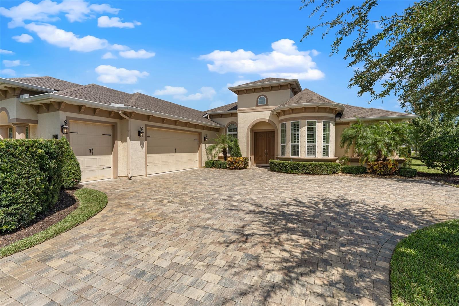 Stunning Lakefront Home in Plantation Bay with 3 Bedroom Suites, Plus Office, and Hurricane Shutters. Welcome to this beautifully designed residence in the gated, golf-cart friendly community of Plantation Bay Golf & Country Club, where every bedroom features its own private bathroom and serene water views take center stage. From the moment you arrive, the paver driveway, side-entry three-car garage, double door entry, and lush landscape lighting set the tone. Inside, soaring ceilings, tile floors, and elegant tray details create an open and inviting feel. The family room impresses with triple vanishing sliders that seamlessly expand your living space to the lanai, plus surround sound and high tray ceilings. The chef's kitchen offers granite countertops, a large island, GE Profile built-in appliances, reverse osmosis system, dovetail soft-close cabinetry with pull-outs, and a custom pantry closet. A charming breakfast nook with plantation shutters captures panoramic lake views while the formal dining room features a tray ceiling, niche detail, and abundant natural light. The spacious primary suite boasts dual custom walk-in closets, a bay window with plantation shutters framing lake views, and private lanai access. The spa-inspired bath includes an extended granite vanity, dual sinks, oversized walk-in tile shower with mosaic accents, and private commode room. Two additional large bedrooms each enjoy their own ensuite baths, one with direct lanai access and walk-in closet. A front office with double doors and plantation shutters provides the perfect work-from-home space. Step outside to the extended lanai, spanning the width of the home, with pavers, surround sound, and breathtaking views of the lighted lake fountain. The home also includes a powder bath for guests, oversized laundry room with cabinetry, folding counter, and storage, plus a garage outfitted with epoxy floors, built-ins, Culligan water filtration system, golf cart bay, and hurricane shutters. Additional features include a hybrid hot water heater, generator plug, gutter system, and professional landscape lighting. Plantation Bay offers a prestigious lifestyle with optional memberships to world-class amenities: 45 holes of championship golf, 9 lighted tennis courts,10 pickleball courts, fitness center, spa, resort-style pools, walking trails, brand new 30 million dollar clubhouse, additional Prestwick Clubhouse, events calendar, and full lifestyle. Buyers of this home to receive a substantial discount on initiation fee at the club. Ask listing agent for details. Don't miss the opportunity to own this immaculate lakefront retreat where luxury meets convenience in one of Ormond Beach's most sought-after communities.