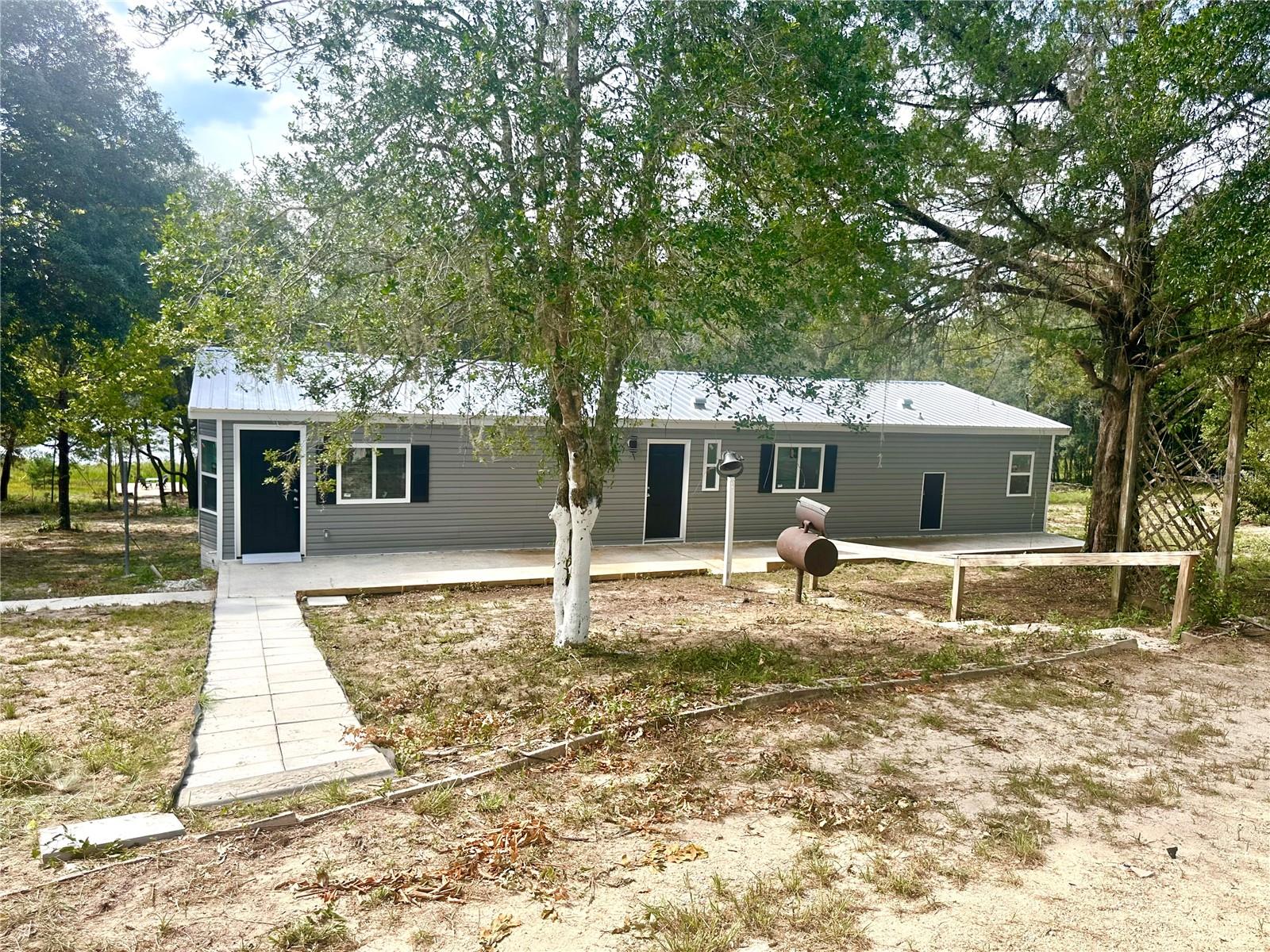 FULLY RENOVATED 3 bedroom/2 bathroom mobile home on 2.4 acres on a private LAKE off a paved road between Hawthorne & Melrose, FL! This home has been fully redone, everything new - metal roof, HVAC, hot water heater, septic, well pump & water treatment system, all new windows, doors, exterior siding, wooden deck, interior drywall & paint, lighting, kitchen, bathrooms, it is all new! Just move in and enjoy! The home also boasts a new wooden dock down by the lake to enjoy beautiful sunsets and to relax in nature. There is a double carport for covered parking, a storage shed and a conditioned bonus space that could be used for a home office or an additional guest room or work out space- with all new LVP flooring, ceiling fan & a new mini split HVAC! This property has so much to offer and is an easy commute on all paved roads to Gainesville, Palatka or Ocala! No HOA and room to relax and enjoy the nature that surrounds you in your own private paradise! Would be a great weekend lake getaway! Call to schedule your showing today!