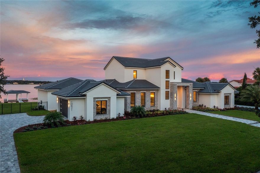 Don't miss this rare opportunity to own the only new construction home currently available on the Butler Chain of Lakes. Just completed, this stunning transitional modern masterpiece is sure to take your breath away, featuring 200 feet of private, unobstructed views of Lake Down, on the famed Butler Chain of Lakes. As you step through the oversized steel pivot door, your eyes are immediately drawn to the 2-story foyer and wall of glass overlooking the pool and lake. The bright, open floor plan is perfect for entertaining with detailed ceiling features and fine finishes throughout. The gourmet kitchen features a large quartz waterfall island overlooking the great room and dining area, custom cabinetry, quartz countertops and backsplash, top of the line Thermador appliances, a 60-bottle wine tower, and a huge walk-in pantry with an additional refrigerator. The primary bedroom suite offers one-of-a-kind lake views and a spa bath with walk-in shower, freestanding tub, and a massive walk-in closet with direct access to the laundry room. Additional features on the first floor include a home office, guest bedroom suite, mudroom, and a game room with corner sliders that open to the 1,500 square feet of covered lanai with motorized, retractable screens, seamlessly blending indoor/outdoor living. On the second floor you will find 2 additional ensuite bedrooms and a set of barn doors opening into a large bonus room/flex space with expansive views. This amazing residence is the epitome of luxury lake front resort living with sliders opening to a custom summer kitchen, outdoor bar area, linear gas fireplace, living area, and dramatic pool and hot tub. The 200ft concrete seawall and new boat dock enable lakefront living at its finest, with expansive views unique to this property to enjoy watching the morning sunrise over the lake and rocket launches from Cape Canaveral in the evenings. For car enthusiasts, the property boasts a 4-car side entry garage (2 on each side). Located in the heart of Windermere, this property is at the very end of a long cul-de-sac, for the ultimate in privacy and serenity with no HOA. Enjoy being just minutes from Windermere A rated schools, the Friday farmers market, quaint eateries, and a short drive to world class shopping, fine dining, and the Disney and Universal theme parks. Call today for a private tour.