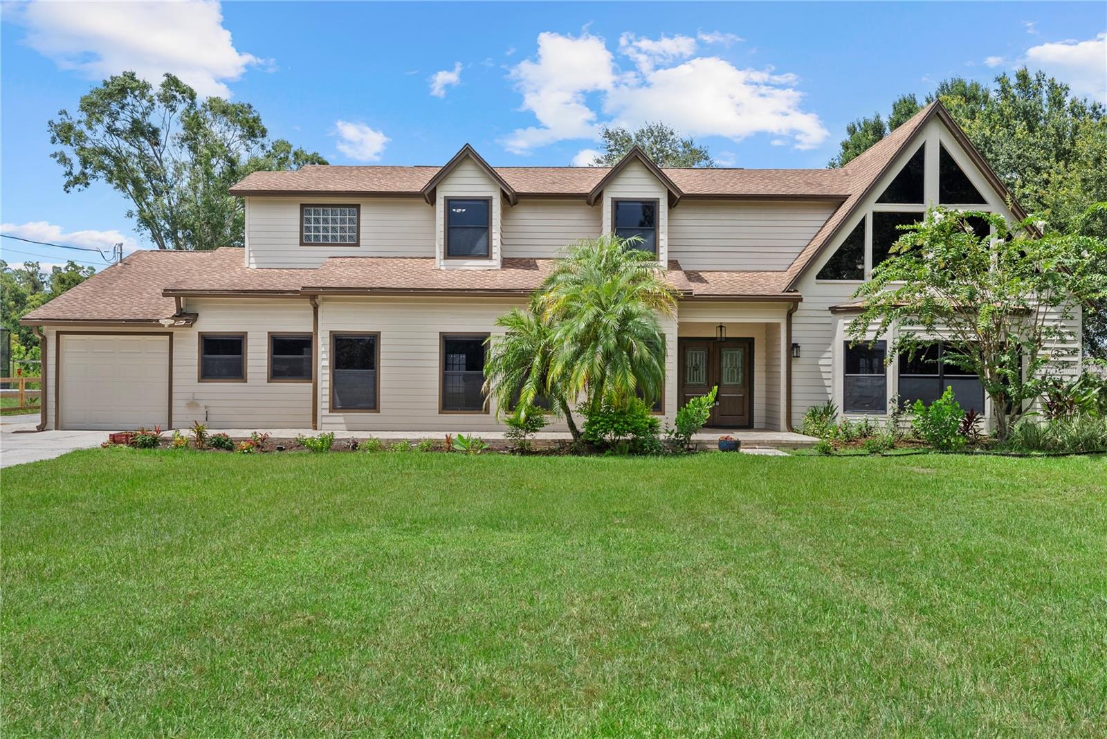 Schedule Your Showing Today! Discover this spacious home nestled on a 1.36-acre homesite in the heart of Wesley Chapel, Florida. Perfect for hobbyists or business owners, this property includes an impressive 80' x 40' workshop with four oversized garage bays and a concrete driveway that stretches from the front entrance all the way to the workshop in the rear. Step inside to a welcoming great room filled with natural light, featuring soaring cathedral ceilings and a cozy fireplace — an ideal space for entertaining family and friends year-round. Enjoy outdoor living with two covered, screened-in patios, where you can relax and take in the peaceful surroundings with your favorite drink in hand. The layout is thoughtfully designed with one bedroom and a full bath on the main level, perfect for guests or multi-generational living. Upstairs, the primary suite and third bedroom each offer their own private bathrooms. The primary suite also features a private balcony, providing a tranquil space to unwind. Conveniently located with easy access to I-75, making commuting and travel a breeze! Don’t miss this rare opportunity to own a versatile home with room to grow and space to breathe!