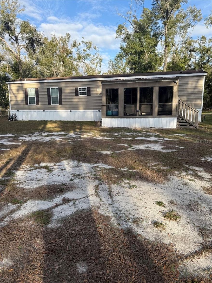 Tucked away in the heart of North Florida, this beautiful 2019, 2 bedroom / 2 bathroom mobile home offers the kind of peaceful Southern living that’s getting harder to find. In very good condition and move-in ready, this home welcomes you with a charming front porch and back porch, perfect for sweet tea mornings and quiet country evenings.
Out back, you’ll find a fenced-in backyard that feels like your own private retreat. A chicken coop adds to the homestead charm, while just the right number of mature oak trees provide cooling shade and create an inviting space to gather, relax, and unwind. The backyard is ready for nights around the fire pit, along with all the BBQs, get-togethers, and special events you can imagine — a true Southern setting made for making memories.
For those who need room to work, store, or play, the property features a utility building with an attached carport, a lean-to for vehicles and equipment, and an additional metal carport, offering plenty of covered space.
Located just a short drive from the legendary Suwannee River, this home puts fishing, boating, kayaking, and scenic river days right at your fingertips, while still offering the quiet comfort of small-town Mayo living.
This is more than a home — it’s a place to slow down, breathe deep, and enjoy true Southern charm. Homes like this don’t come along often — schedule your private showing today and come experience it for yourself.