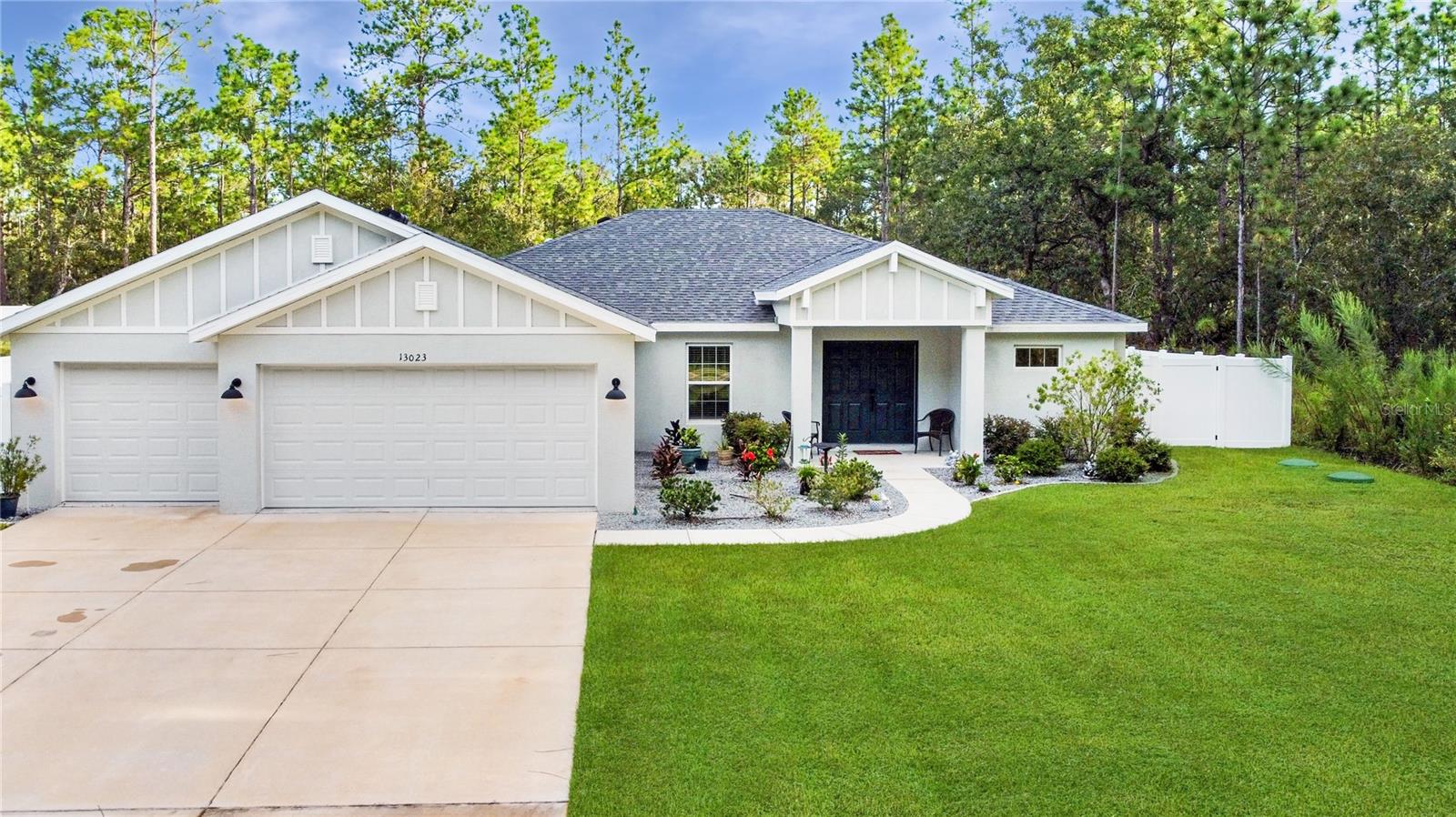 This stunning 3-bedroom, 2-bathroom home with a versatile flex space offers the perfect blend of modern finishes and peaceful surroundings. Built just two years ago, the property sits on almost a half an acre of cleared, fenced in land and is framed by beautiful pine trees, providing both privacy and charm. Inside, you’ll find wood-look tile throughout the main living areas with plush carpet in the bedrooms for comfort. The kitchen and bathrooms showcase granite countertops, while the kitchen also features stainless steel appliances, a dry bar, and a functional layout designed for both daily living and entertaining. The kitchen also over looks the living room and dinning room. The spacious primary bedroom has dual walk in closets and an en suite bathroom complete with a walk in shower, linen closet, and dual sinks. Step outside to a screened-in rear patio with an extended open patio, perfect for enjoying the view of your expansive backyard. The property also includes a 3-car garage, offering plenty of space for vehicles, storage, or a workshop. With its modern construction, spacious layout, and tranquil setting, this home is truly move-in ready and waiting for its next owner.
