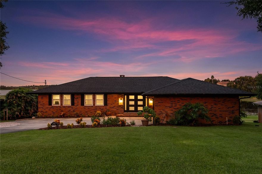 One or more photo(s) has been virtually staged. Situated in the peaceful Suburban Shores neighborhood, this four-bedroom, three-bathroom residence offers a rare opportunity to enjoy waterfront living with the convenience of being minutes from both Winter Garden and the rapidly expanding Clermont area. Positioned on nearly half an acre with 81 feet of frontage and unobstructed lake views, this home blends comfort, versatility, and future potential. Inside, the main level features a beautifully open layout with generous natural light, stunning lake views, and a wood-burning fireplace anchoring the living area. The gourmet kitchen is well-appointed with custom cabinetry, stainless steel appliances, a gas cooktop island, and a sleek tile backsplash. The main level includes three bedrooms and two updated bathrooms, as well as a large laundry and mudroom for added function. The lower level is designed with flexibility in mind, offering two expansive living areas, a second fireplace, and a fully remodeled fourth bedroom with en-suite bathroom, a guest retreat, or an additional primary suite. Original terrazzo flooring and triple sliding glass doors invite in lake views and light. A custom wet bar enhances the lower level for entertaining. A recently added covered porch spans the rear of the home, finished with a warm cedar tongue-and-groove ceiling, Trex decking, and custom iron railing. This space overlooks the lake and captures both sunrise views and nightly fireworks from Disney and Universal. Outdoors, the oversized backyard provides ample space to design a future pool, outdoor kitchen, or other enhancements. The property also offers potential to add a private dock, and residents enjoy access to a shared community dock, beach, and public boat ramp, ideal for anyone eager to enjoy lake activities year-round. Located within Lake County, the home benefits from lower taxes while maintaining a Winter Garden address. With Clermont’s continued retail and infrastructure growth just west and seamless access to the Florida Turnpike, Hwy 50, and SR 429, this home combines timeless lakeside charm with long-term investment potential.