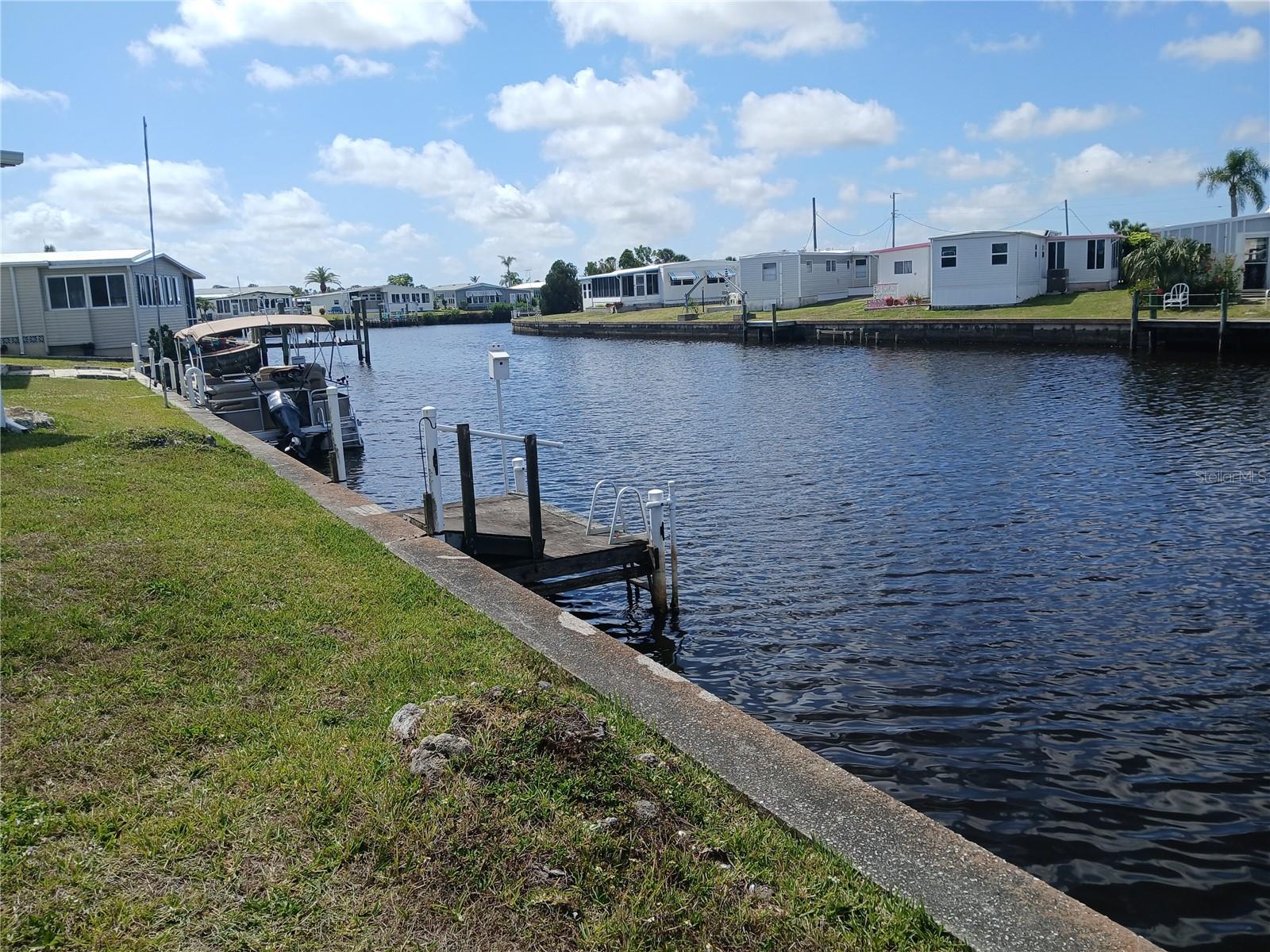 NORTH PORT - HARBOR COVE - A resident owned manufactured home community; vacant lot offers 51 ft. canal waterfront, with dock, and canal to Harbor and Gulf access; low monthly maintenance fees include pool, tennis & pickleball courts, shuffleboard, ground maintenance, recreation facilities, storage, etc. , and enjoy all of the amenities at HARBOR COVE.