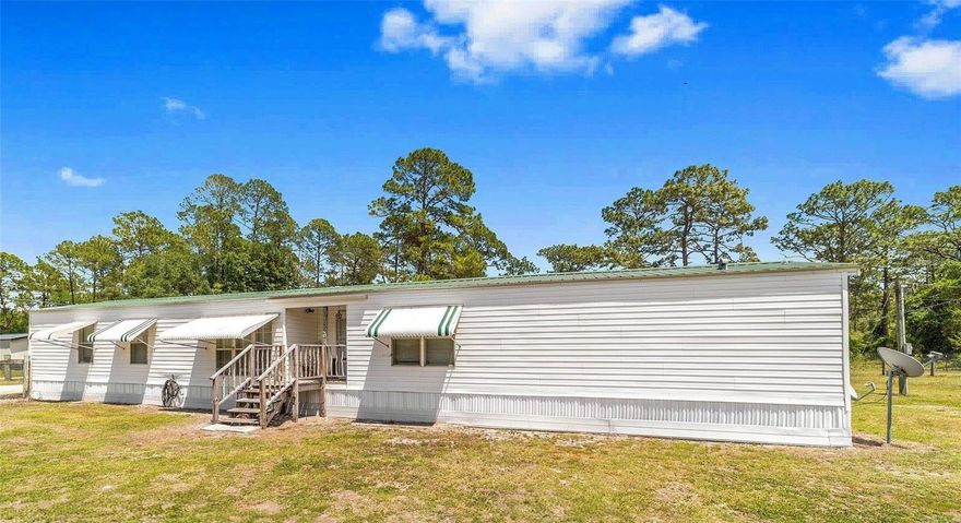 (Some pictures are virtually staged) RARE FIND_ 3/2 CLEAN Country Charmer has Everything you are looking for. Peace & Quiet, Room inside & out. Bring your toys, you have just under 3/4 acre to play. NO HOA, NO Rules. No Flood Zone. ALL the FREEDOM to live as you choose. One storage shed  comes with the home, (a second shed is available) all on the oversized lot you want. The Updated Features include: Fresh paint inside & out, pressure washed exterior, Modern Luxury Vinyl Plank FLooring throughout, NO CARPET.  METAL ROOF, Newer HVAC, 4" well for great pressure, Cozy FIREPIT is waiting. Its Summer-Its time for  campfires and SMORES! Your Kitchen has glass top stove, Lots of counter space, Built in additional storage for kitchen needs or for Books/Homework. Space to eat together ,everyone around the same table, over looking country views of open fields, trees, horses and cows. Exhausted after work? Come home to a Spacious Bathroom with His & Hers sinks, long counter, seperate shower and a LARGE SOAKING GARDEN TUB, you can actually lay down in. Primary Bedroom has HIS and HERS closets.  Guest Wing has TWO BEDROOMS & bathroom has a shower/tub combo . You found your  Forever Home. The bonuses don't stop on the inside. Outside you find  you are on a CORNER LOT , fully FENCED yard with a single & a DOUBLE GATE, large parking pad, AND...,the home has a SURVEY (saves you 400+ $$$) and an Engineering Cert for the tiedowns and permanent foundation($$$ 4K+) ,newer skirting complete with durable weed barrier thats weed eater proof. There are ALSO hurricane awnings on the windows, easy to secure for quick weather proofing. SAVES YOU EVEN MORE $$$ on INSURANCE. Serenity  and peace of mind, right here in Fort MCCoy. You can lead the quiet life but still be a short drive to needed shopping, yet be within an hour to 5 AMAZING Springs, right here in the Ocala National Forest. Forget the Beach with sharks. Go to Juniper Springs and dive for sharks teeth, Go see the otters and monkeys at Silver Springs, Alexander Springs always has amazing sights, Salt Springs is literally around the corner....Glen Springs too..the list keeps going. Only an hour from world Famous Rainbow River or hour and a half from Daytona Beaach. or an hour and a half to the Gulf-Cedar Key. This is Central Florida living at its Best! Private but still just minutes to the local Grocery store, Local hardware & Feed store, Post Office, Library, Local Doctor, Hair Salon, Dollar General and strip mall. *Corner Lot * Freshly painted * Modern Washer & Dryer included