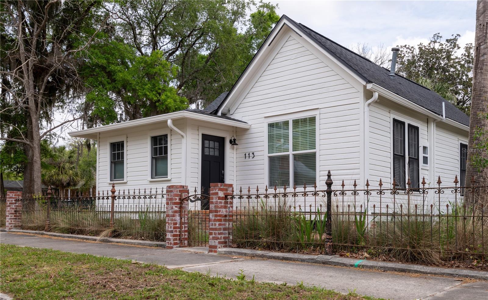 Stunning historic home completely transformed in 2019! The thoughtfully-designed addition brought valuable square footage and maximum function to this classic Duckpond home. Special features like the loft in the third bedroom, the hidden laundry behind a custom barn door and custom storage in the entry wisely utilize every inch of space. The kitchen features a decorative fireplace, updated cabinetry, wood countertops and seating for the dining area. The simple and understated hall bathroom features a solid wood vanity, clawfoot tub, wainscoting, sconce lighting and penny tile flooring. Gorgeous lighting fixtures, solid wood floors, tall ceilings and beautiful windows throughout. Outdoor living is easy with the fabulous wrap-around porch, fountain, brick patio, decorative metal fence and charming gardening shed. All the major systems have been updated including plumbing, electrical, roof and HVAC. The neighboring property is also just hitting the market, so this is an ideal opportunity for multi-generation living or passive income in your backyard. Just a short distance to downtown Gainesville and the University of Florida, this is one to see!