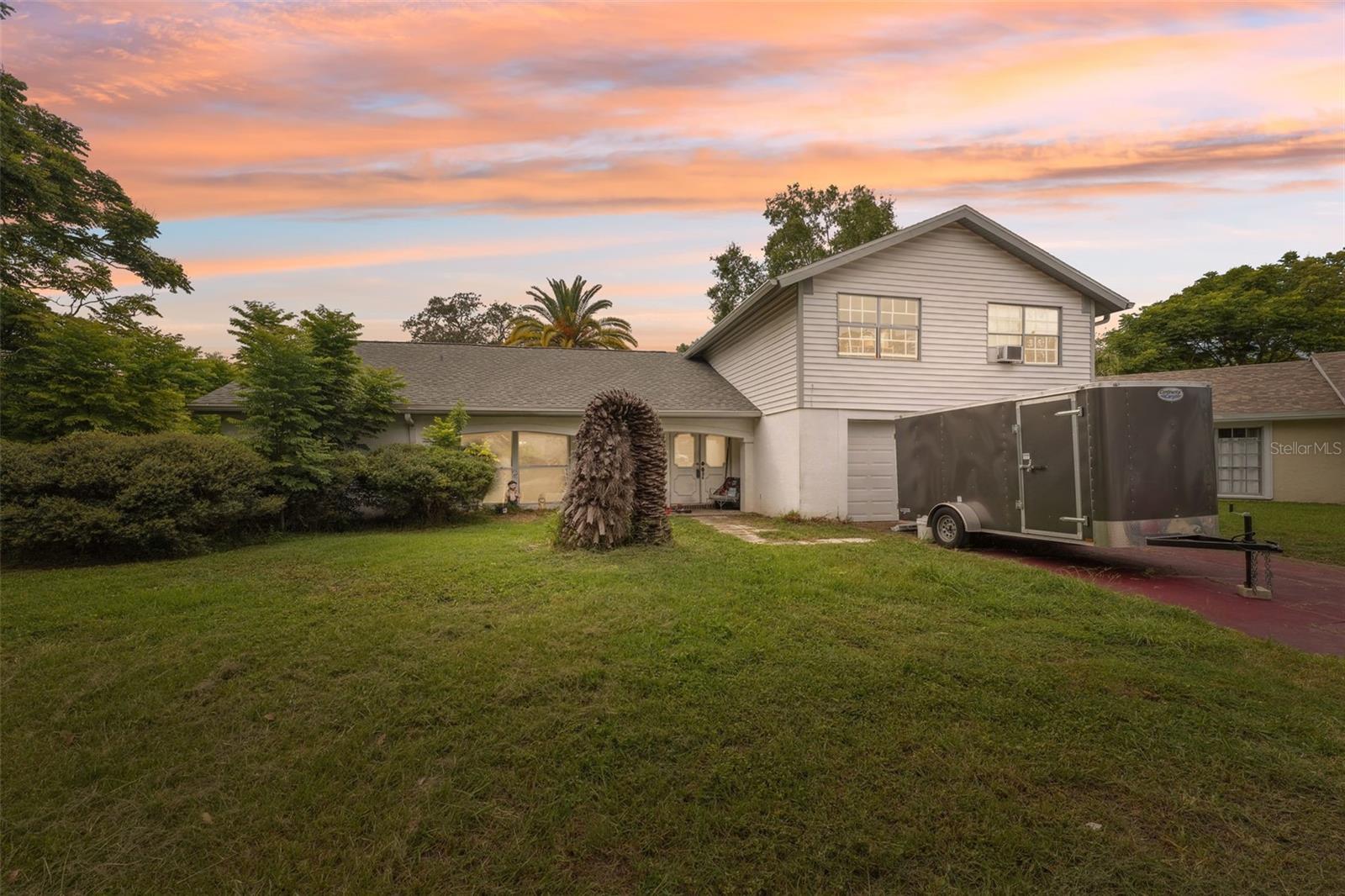 One or more photo(s) has been virtually staged. Nestled at the end of a quiet cul-de-sac, this two-story, four-bedroom, three-bath home offers sweeping pond views from an oversized, irregular lot framed by mature trees, creating a truly “old Florida” feel. A spacious covered front porch welcomes you, perfect for enjoying the breeze, and inside, a foyer opens to a bright living room with floor-to-ceiling windows flowing into a dining area with three sliding glass doors that reveal an expansive Florida room overlooking the tranquil water. Adjacent, a flexible family room could serve as a home office, playroom, or media lounge, and the separate kitchen is bathed in natural light from multiple windows. The primary suite also enjoys full-height windows, a walk-in closet, and a private bath with a walk-in shower. A convenient laundry room offers direct access to the chain-link-fenced backyard, which is bursting with character and highlighted by stunning pond and woodland views. While the home needs updates, its solid framework and thoughtful layout make it an ideal blank canvas for a beautifully refreshed residence. Located just 4 miles from the Suncoast Parkway (SR 589), this property grants streamlined, limited-access travel into Tampa—making daily commuting smooth and reliable. And when it's time to play, you're only 8 miles from Hudson Beach, where local favorites like the Inn on the Gulf serve fresh seafood with breathtaking Gulf views, or Sam’s Beach Bar which offers a laid-back beach vibe with seafood and tropical cocktails at sunset. Just 5 miles away, Werner-Boyce Salt Springs State Park provides opportunities for hiking, kayaking, and wildlife viewing, while a short 15-mile drive takes you to Weeki Wachee Springs State Park for swimming, kayaking, and exploring crystal-clear springs.