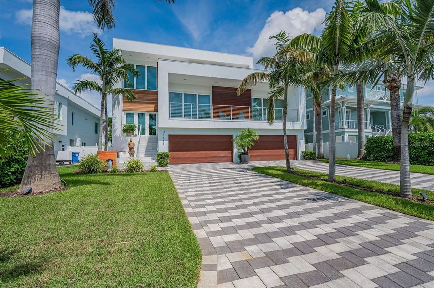 ELEGANT COASTAL CONTEMPORARY WATERFRONT LUXURY IN ONE OF TAMPA BAY’S MOST EXCLUSIVE BOATING COMMUNITIES!  A dazzling signature driveway with towering Royal Palms welcomes you to a beautiful, purposefully-designed custom estate residence with an inspired focus on waterfront living.  Step up to an impressive great room plan with sweeping water views and a soaring 21ft high living area.  Lovely level 5 wall finishes, rich wood flooring and seamless window treatments deliver a relaxing minimalistic appeal.  The impressive gourmet kitchen boasts gorgeous quartz surfaces, superb backsplash tilework, high-quality stainless steel appliances, gas cooking, resplendent coastal white cabinetry and a huge center island prep center and breakfast bar with generous seating for five.  You will appreciate the inviting waterfront dining area – perfect for both formal and informal occasions.  Opening to the waterfront balcony, the wonderful living area is supported by an exquisite custom-built wetbar with dedicated icemaker and beverage/wine chilling center.  Step out the towering covered waterfront balcony; this wide balcony offers terrific views, exceptional finishes, a tall privacy sunshade and access to the lower level.  Two plush bedroom suites contain walk-in closets (with closet systems), lavishly-finished full baths and private access to a wide shared covered balcony with south-facing water views. 3rd bedroom faces the water and enjoys a gorgeous full guest bath.  Upper level opens to the magnificent owner’s suite with commanding panoramic water views, spacious sitting area, two sizable walk-in closet systems, and a private covered waterfront balcony.  Owner’s bath is luxuriously-finished with quartz surfaces, two large vanities, a dedicated sit-down cosmetics center, a posh stand-alone Kohler soaking tub, and a lavish oversized walk-in glass rain shower enclosure with body sprays.  The upper level loft overlooks the waterfront and provides a substantial casual sitting/living space with built-in wet bar and access to a wonderful common balcony overlooking the water.  Upper level also gives access to a huge 370sqft partially-covered open deck overlooking the waterways to the south – a space that is ideal for sunsets and early evenings.  Lower level includes an exceptionally clean 4-car garage, and a 1300+ sqft multi-purpose entertainment/storage/fitness space that opens to a 350 sqft covered deck overlooking the pool and waterfront.  Your stunning Pebbletec pool/spa with sunshelf is complemented by a large travertine paver deck that supplies plenty of lounging/dining space.  The updated seawall and composite dock with seating bench, supports a 13,000 lb boatlift – for easy, rapid access to the intracoastal waterway and the Gulf.  3-stop luxury elevator, epoxy garage flooring, and many, many extras.  A rare opportunity - this is an extraordinary modern luxury home in outstanding condition.  Dimensions are estimates, buyer to verify. Assumable $654 FEMA Flood policy.