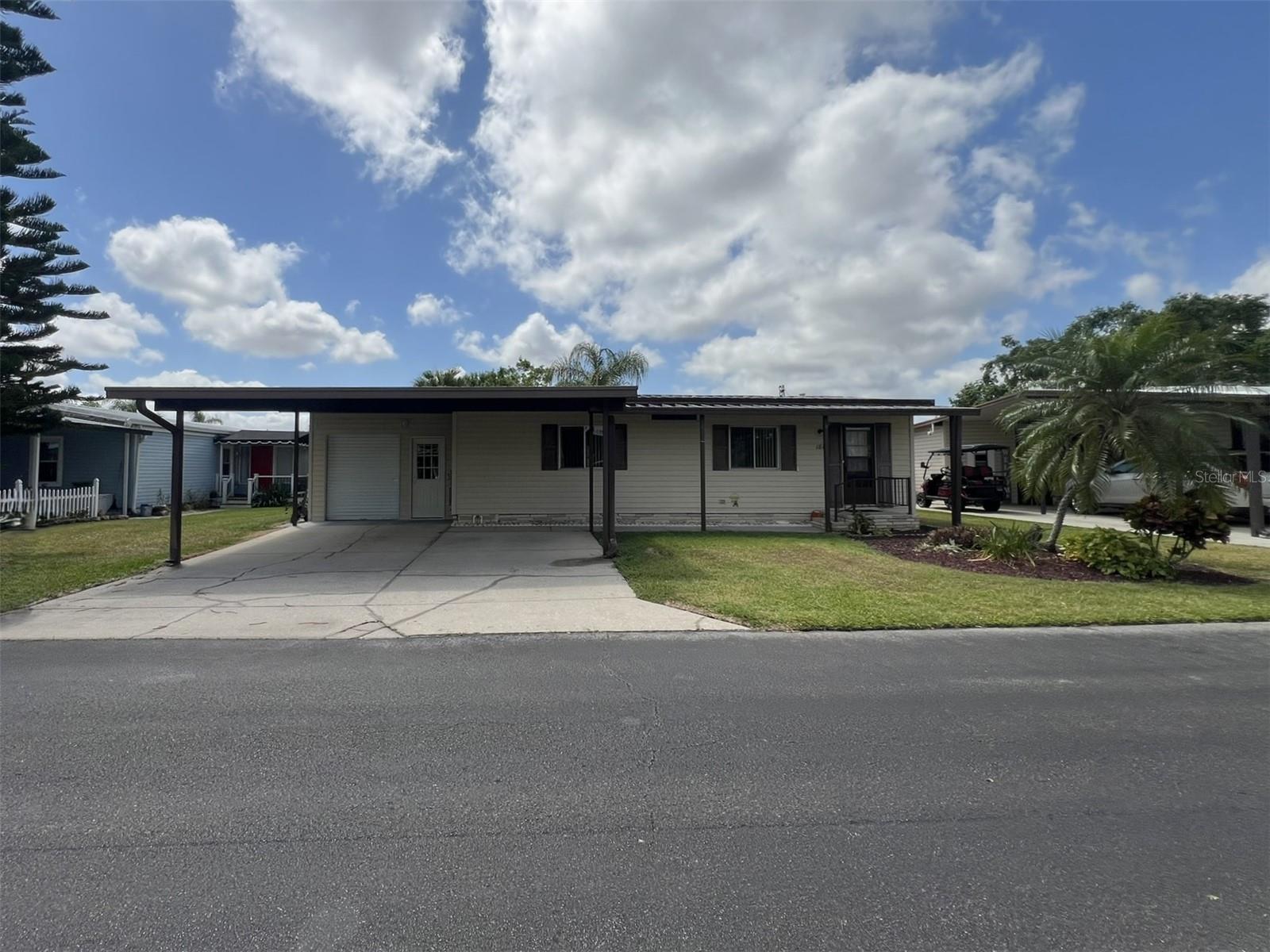 This furnished and MOVE-IN READY 2 Bedroom, 2 Bathroom manufactured home in the 55+ Floral Lakes Community in Bartow, FL is situated waterfront on Big Bass Bay and features a spacious Kitchen with breakfast bar, dishwasher, and built-in pantry with custom slide-out drawers; a separate Dining Area; and Living Room with oversized sliding glass doors that open into the enclosed rear patio, creating an expansive and seamless transition between indoor and outdoor living areas.
Enjoy a view of the water right from your bed through the sliding glass doors in the Primary Bedroom with walk-in closet (mirrored door) and a linen closet. The Primary Bedroom’s en-suite bathroom features a shower enclosure with sliding glass door. Bedroom 2 features three closets, one a walk-in. The Guest Bathroom features large vanity and shower/tub combo. A new washer and dryer (included) are located off the rear porch, in the spacious laundry room, complete with wash tub and storage shelves. Concrete steps leading to the wooden dock provide ease of access, so you can fish Big Bass Bay right from your backyard!
Double carport, plus enclosed golf cart garage with power garage door opener.
Located in central Florida, between Tampa and Orlando, this golf cart friendly community is near the Bartow Civic Center, Bartow Public Library, and Mary Holland Park. Here you OWN YOUR LAND (no lot rent) and pay low monthly HOA fees. The Floral Lakes community offers access to a stocked pond with community boat ramp and dock. Clubhouse amenities include recreation space, shuffleboard, putting green, and large heated swimming pool. Social clubs, dances, exercise, pot lucks, and MORE! Association approval is required for purchase. Call your Realtor today for more information and to schedule a showing!