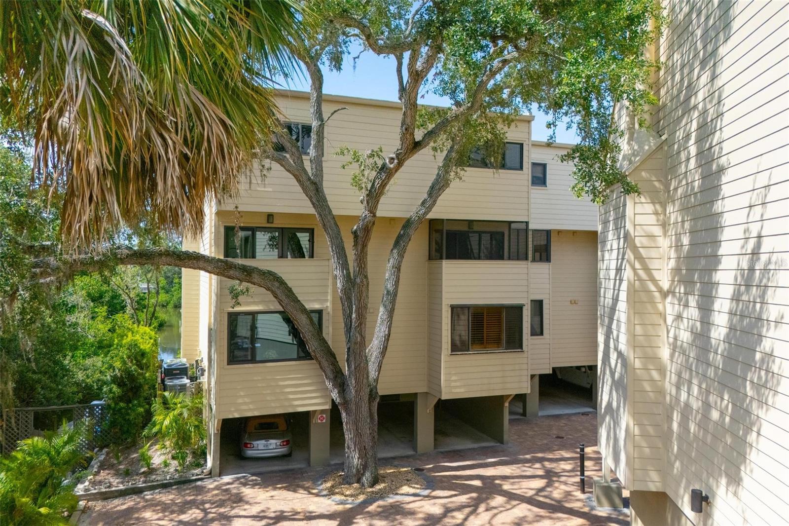 Hudson Oaks offers true waterfront living in the heart of downtown Sarasota, set in a lush and tranquil setting with water views and boating access. This beautifully updated 2-bedroom, 2-bath, two-story condo is part of a hidden gem community tucked between historic Laurel Park and vibrant Burns Court. You’re just minutes from Sarasota’s top restaurants, boutique shops, Selby Gardens, the Bayfront, and a short ride to Lido Beach and St. Armands Circle.
Hudson Oaks offers a blend of waterfront serenity and downtown convenience. Residents enjoy access to private boat docks, a kayak launch, swimming pool, grilling area, and a pedestrian bridge that connects directly to Laurel Park. The Hudson Bayou is a protected waterway with small boat access to Sarasota Bay—ideal for kayaking, paddleboarding, or simply taking in the views.
Inside, the home features a split-bedroom layout with both bedrooms located upstairs for privacy. The primary suite includes a walk-in closet and a private covered balcony with beautiful views of the water. The en-suite bathroom has been tastefully renovated with an upgraded vanity and a walk-in tiled shower with a glass door. The second bedroom is also spacious and filled with natural light. A fully updated guest bathroom with a modern vanity and tiled walk-in shower completes the upper level.
Downstairs, the open-concept living and dining areas are bright and airy, with large sliding glass doors leading to a balcony that overlooks the bayou—perfect for relaxing or entertaining. The updated kitchen features granite countertops, pull-out shelving, stainless steel appliances, a subway tile backsplash, and a pantry closet. A large center island offers additional prep space and room for casual seating. The layout is open to the living area and offers direct access to the fully screened-in balcony off the kitchen with a peaceful view of the pool, offering a separate outdoor space to enjoy.
Recent upgrades include a new roof (2020), kitchen renovation (January 2025), and refreshed bathrooms with new vanities, sinks, faucets, and toilets. All windows and sliding doors come with clear hurricane panels, which are included in the sale. This condo also comes with the largest storage room in the building—perfect for bikes, beach gear, or seasonal items—and a covered carport with an EV hookup, exclusive to this unit in Building B. A floating dock is also included with the purchase.
The HOA is financially strong and fully compliant with Florida’s updated SIRS (Structural Integrity Reserve Study) requirements, with a licensed reserve study specialist having completed the analysis.
Schedule your private showing today and experience this rare opportunity for waterfront living in downtown Sarasota.