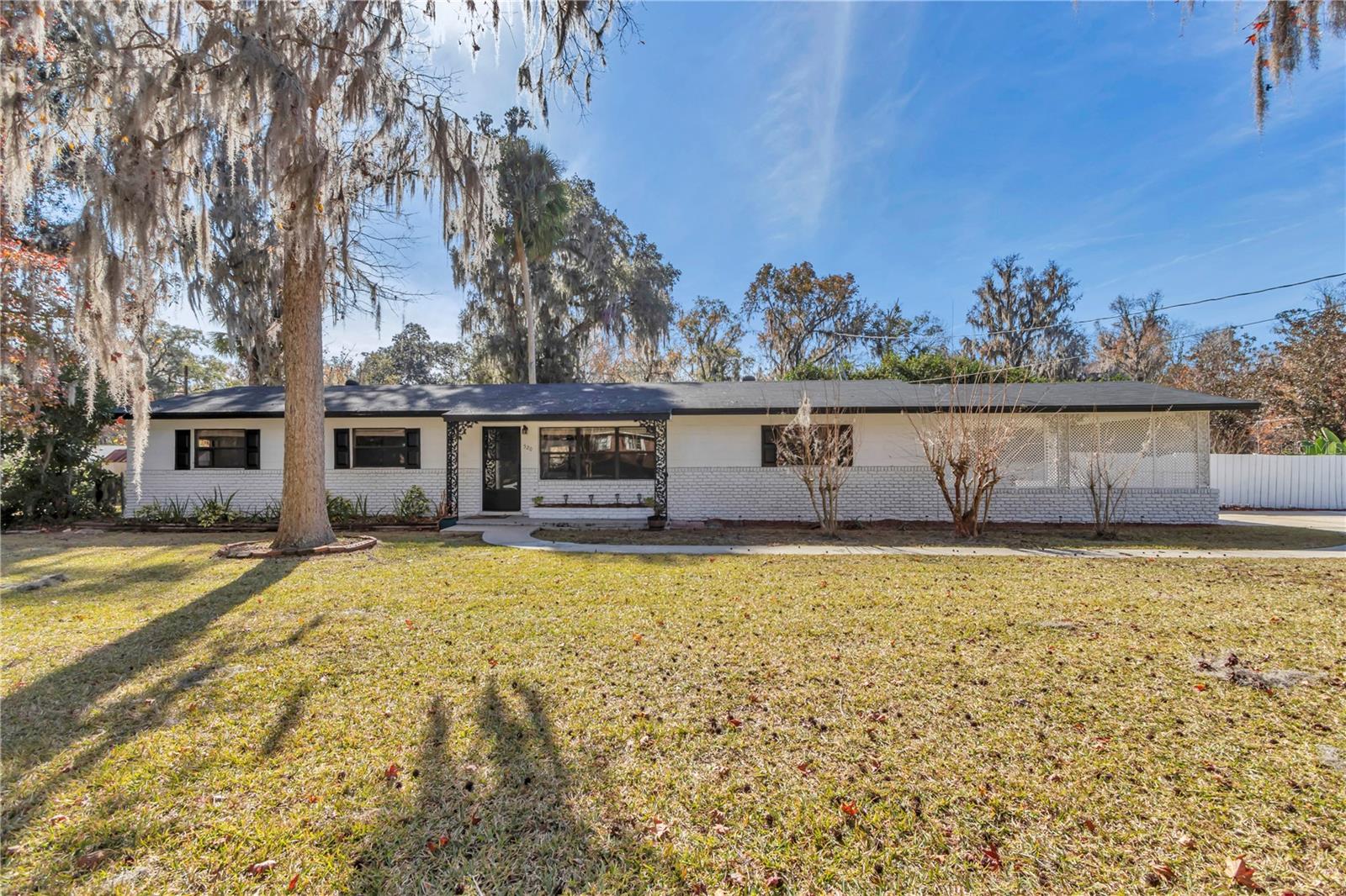 Incredible curb appeal on oversized ( 1/2 an acre), corner lot with no HOA, in-ground pool, private backyard and storage shed! Covered front porch leads to Modern, renovated home with whole home luxury vinyl plank. Spacious living room overlooks kitchen with Peninsula Island with upgraded granite countertops, brand new cabinets with nickel handles. New stainless steel refrigerator and stove. The kitchen overlooks the breakfast area leading to oversized covered floor room with beautiful views of the large inground pool with oversized sun patio. This is a true three bedroom three full bath home featuring split bedroom plan. Primary bedroom is to the right of the home and is oversized with glass door surround shower. Leading back across the home into the spacious laundry room and mudroom! Across the home is the second bedroom with en suite bathroom with glass door modern finishes. The third bedroom is basically two rooms in one with sitting area. Your guest can use the bathroom off the hallway with glass sliding door and modern finishes, including new cabinetry and oversized granite vanity. 2021 roof, Hvac 2018 and 2022 hot water heater. 2025 pool pump Stepping outside of the Florida room outside the double sliding glass door to your backyard oasis that has privacy fence and has a storage shed as well. 2 car carport great for parking or covered shade for pool! All super close to Grand Oaks marketplace, the theater and downtown!