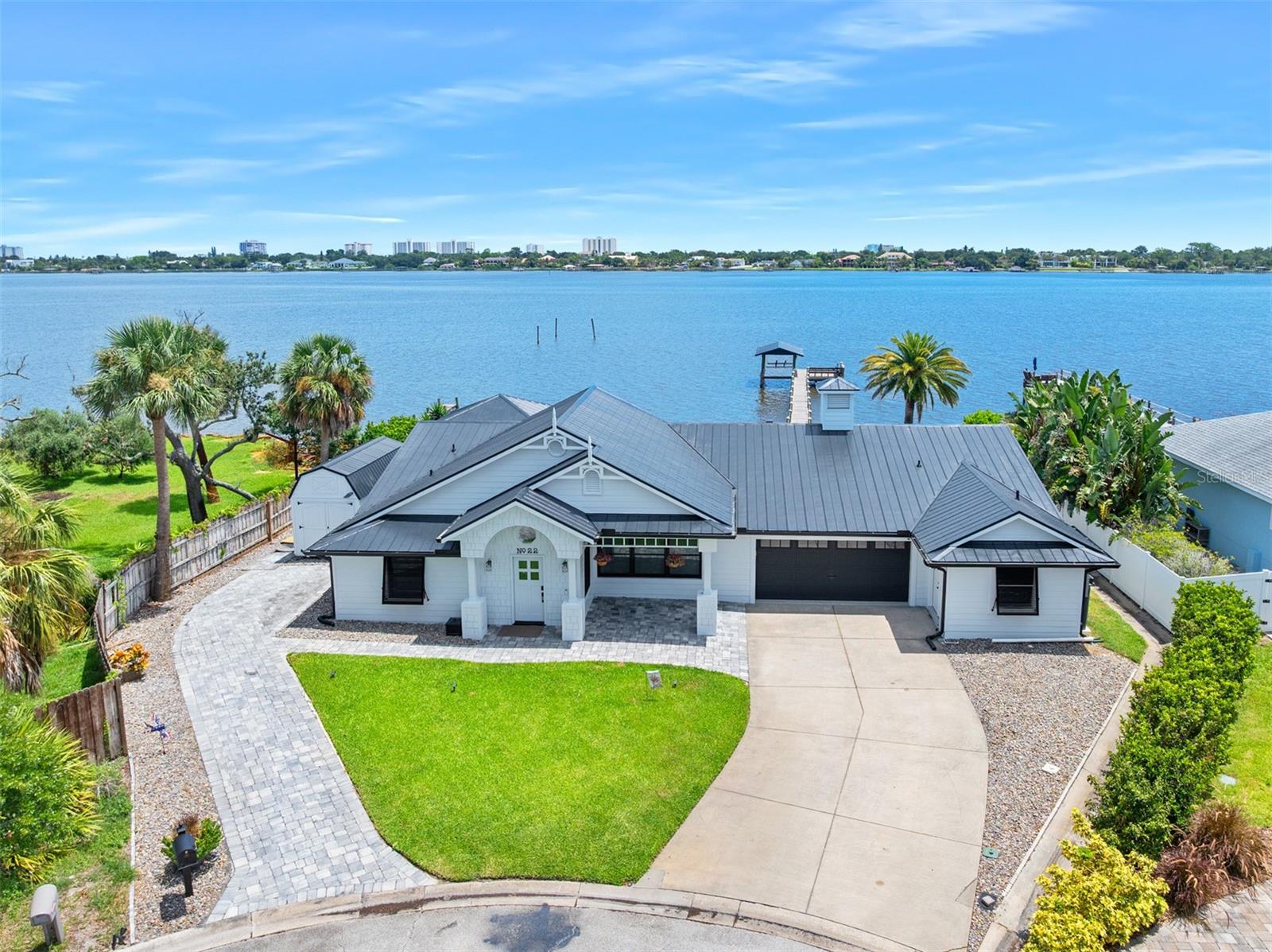 Ormond Beach waterfront opportunity. Due to an unexpected relocation, owners are offering this fabulous pool home after an extensive renovation. This 4 bedroom, 3 bath home offers over 3500 sq ft of casual, coastal living spaces both indoors and out. Enter the home to be greeted by river views from the sprawling great room where living and dining spaces center around a poolside island kitchen. The new kitchen features stunning quartz tops over solid wood cabinetry that compliments high end appliances including the 48" gas range with pot filler and commercial grade copper vent hood. This chef's space is situated beneath tongue-n-groove vaulted ceilings and includes a sizable pantry, wine cooler and a porcelain farm sink overlooking the water. The waterfront primary suite with dedicated office occupies a private south wing of the home with volume ceilings, his and her walk-in closets and a gracious bath with double vanities, private water closet and cavernous shower for two. A second waterfront suite on the opposite side of the home also opens directly onto the poolside waterfront patio and features a walk-in closet and lovely new en-suite bath. Two additional bedrooms share a spectacular new bath and a dedicated hallway with pocket door. Finally, step out onto the terrace and enjoy pure privacy created by lush landscaping where a sparkling blue, custom heated pool and spa sit adjacent to the inviting cabana that was designed to serve as the outdoor living and dining space. A substantial coquina seawall is in place and the 130' dock with lounging deck and covered boat house are ready for fishing and watersports. Indoor utility room. Two Car Garage plus a unique 11'x11' finished workshop that could serve as a home gym, hobby room or office space. A long list of recent upgrades are on file that include new AC systems, instant tankless hot water, new Anderson windows, new pool equipment/heater, and Culligan water treatment system. This home sits high above the water and has no flood history. Only 7 quiet cul-de-sacs exist in this in this special location just 2.5 miles north of Granada Blvd and only 20 waterfront homes are situated along the shoreline of the intracoastal waterway. Treasured by locals for decades this location is beloved by the few who get to call it home and enjoy the predictable ocean breezes and sunrises from The Atlantic Ocean in the far distance while boaters and outdoor enthusiast enjoy direct proximity to The Tomoka River and Tomoka State Park 1.5 miles to the north.