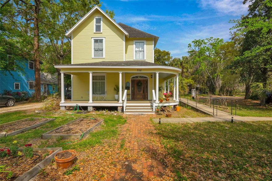 This gorgeous Victorian home sits on the edge of Gainesville’s beloved Duckpond neighborhood, just minutes from Downtown, Depot Park, and the Hawthorne Trail. With timeless charm and versatile space, this property is perfect as a private residence or could easily be converted into a unique commercial office. The home features six bedrooms with soaring ceilings and abundant natural light, along with two and a half bathrooms. The expansive chef’s kitchen is a standout, offering extensive cabinetry, a coffee bar, and a separate pantry—ideal for entertaining or collaborative office use. A dedicated laundry room provides additional storage along with a washer and dryer.
The inviting living room features original pocket doors and a decorative fireplace, while bedrooms #1, 4, and 5 also showcase charming, non-functioning fireplaces that add character throughout. A bonus room offers the perfect space for an office, studio, or extra storage. Outdoors, the oversized yard invites relaxation, with room for grilling, gathering, or even garden installations. A wraparound front porch and two back decks create even more space for enjoying the outdoors, and a large metal shed provides secure storage for bicycles or equipment. One of the home’s most valuable features is its huge private parking lot, offering over 12 off-street spaces—an uncommon amenity that would greatly benefit a commercial office setup. The property also includes central heating and air conditioning, with mini-split units in each bedroom for personalized comfort. Whether you’re looking to invest in a beautifully preserved historic home or convert a standout property into a boutique office, this Victorian gem offers unmatched potential in a prime Gainesville location.
