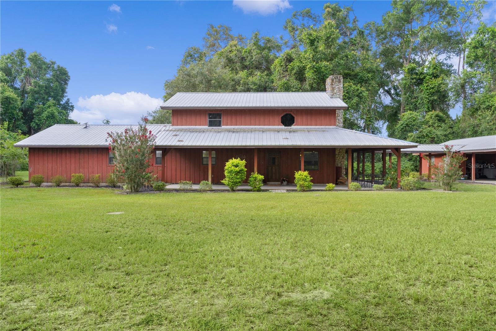 Privately set on 7.2 acres in Wildwood, this versatile property offers the space and flexibility ideal for trades, trucking, or personal business—just minutes from The Villages with direct access to I-75, Florida’s Turnpike, and Ocala. The custom-built home blends comfort and practicality with warm wood accents and a rock fireplace, while recent upgrades bring peace of mind: metal roof (2010), all-new plumbing (2021), updated electric (2023), new well pump (2024), full-house Generac generator with underground propane tank, and a solar-powered entry gate.
The layout includes a spacious primary suite with a walk-in closet, office, and built-in 36-gun safe—perfect for secure storage or workspace. A walk-in shower with grab bars adds everyday convenience. Outside, the property shines for anyone needing serious storage or working space. A brand-new 60x130 shop/pole barn offers endless possibilities—use for equipment, vehicles, or future build-out. You’ll also find a 33x40 pole barn, a 20x20 garage with workbench, A/C and lighting, plus an above-ground pool, concrete parking pad, and additional covered storage for tools or trailers. No HOA, no hassle—just usable land, smart upgrades, and room to grow your business or enjoy country living your way.