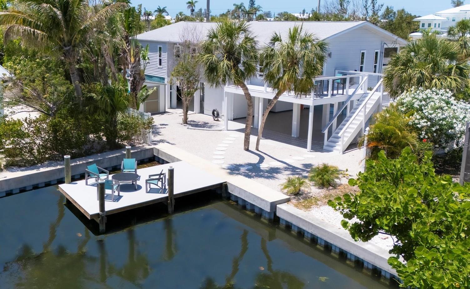 This completely remodeled, ELEVATED waterfront home in the popular Key Royale neighborhood of Holmes Beach on Anna Maria Island - a true paradise for beachgoers & boating enthusiasts alike. Situated on an oversized corner lot, this southern-facing 3-bedroom, 2-bath retreat offers breathtaking water views, a resort-style pool/spa, & direct deep-water canal access to the Gulf & Tampa Bay with no bridges & two blocks to the beach. This home features a new seawall & a 20x12 Trex dock right on the water, perfect for watching the sunrise, soaking in the island lifestyle, watching dolphins & manatees glide by or launching your kayak. The home is built for peace of mind with updated impact-rated doors, windows, garage door - providing added security & energy efficiency. As you enter, a grand two-story foyer welcomes you with luxury vinyl plank flooring that runs throughout, striking designer lighting & timeless coastal finishes. Every inch of the interior has been thoughtfully redesigned, from the brand-new interior doors & trim to the completely transformed ceilings. The heart of the home is a bright & airy open-concept layout where the great room, dining area & gourmet kitchen flow seamlessly together - ideal for entertaining or relaxing after a day at the beach. The chef’s kitchen is a showstopper with modern cabinetry, quartz countertops, glass tile backsplash, brand-new stainless-steel appliances with warranties & single-bowl sink with water views from the picture window. Step outside to the screened-in lanai with pocket sliding doors that extend your living space or unwind on the new wrap-around Trex deck overlooking the water. The owner’s suite is a private haven featuring its own balcony with pool/spa access, a spa-inspired ensuite bathroom with a new double sink vanity, quartz countertops & frameless glass walk-in shower. The additional two bedrooms are generously sized & share a beautifully updated bathroom, while the spacious laundry room features a utility sink & brand-new washer and dryer. Outside, the resort-style pool/spa are surrounded by lush privacy landscaping, vinyl fencing, & artificial turf, creating a huge low-maintenance, tropical oasis. The covered patio with epoxy flooring provides the ideal spot for alfresco dining, entertaining or relaxing in the ocean breeze. Pool, dock, & deck furniture are included. Recent upgrades include a new pool pump, WiFi-enabled heater (2025), hot water heater (2025), AC (2023) & covered gutters. In addition to the outdoor storage shed, the spacious 3-car garage with two storage areas provides plenty of room for your gear & golf cart! The xeriscape yard, surrounded by new vinyl fencing & gates for added privacy, offers additional parking for guests, or an RV or boat with trailer! There is a capped artesian well which can be tapped for irrigation or water supply to the home. As a resident of Key Royale, you can join the private Key Royale Club, offering golf, fine dining, & social events. With Anna Maria Island’s white sand beaches just 2 blocks away, this coastal sanctuary delivers the perfect blend of island charm, boating convenience & elevated elegance. Enjoy all the island life has to offer from the free trolley to famous dining, shopping, community pickleball, tennis, basketball courts & dog parks. If you’re looking for the ultimate boater’s paradise near the beach, this home is your dream come true. *INVESTOR FRIENDLY*
