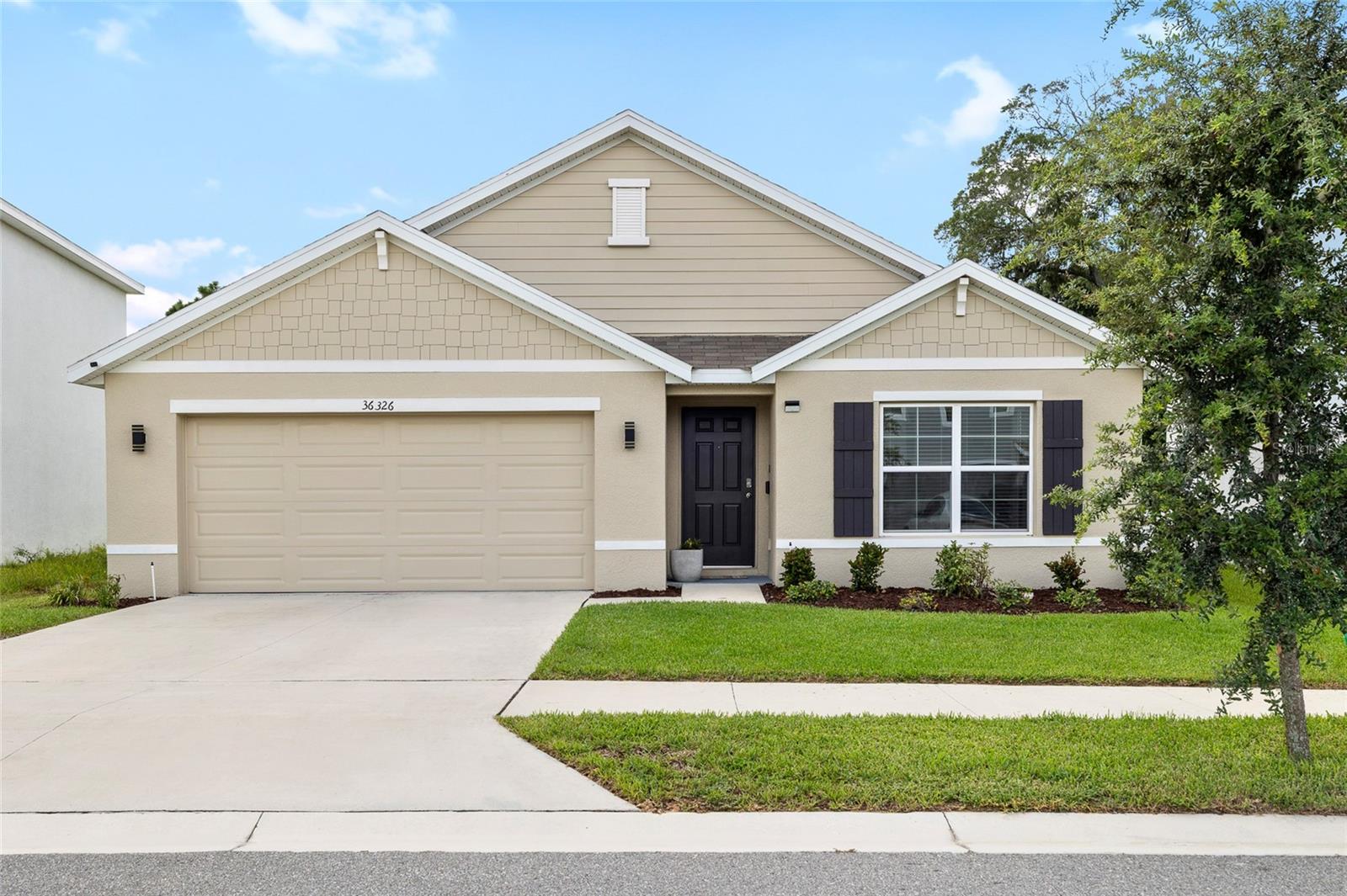 Why wait for new construction? This beautifully maintained 4-bedroom, 2-bathroom home, built in 2022, is completely move-in ready and offers an assumable FHA or VA mortgage at a 4% interest rate for qualified buyers — a rare find in today’s market! Step inside to a smart split floor plan that blends functionality with privacy. Two bedrooms and a full bathroom are located at the front of the home, while a third bedroom near the laundry room is ideal for guests, a home office, or creative space. The open-concept kitchen features granite countertops, stainless steel appliances, a large breakfast bar, and a walk-in pantry — flowing seamlessly into the living and dining areas, perfect for everyday life or entertaining. Tucked privately at the back of the home, the primary suite offers a peaceful retreat, complete with a spacious walk-in closet and an en-suite bathroom featuring dual sinks and a walk-in shower. Out back, enjoy added privacy with no rear neighbors and plenty of space to relax or play. Looking for things to do? John S. Burks Memorial Park is just a short walk away with soccer and baseball fields, a jungle gym, and more. For those craving excitement, the Dade City Raceway is also nearby. This home is in a great location with something for everyone especially families! Located in a quiet neighborhood just minutes from shops and dining, you’ll also love the small-town charm of Dade City from historic streets and local boutiques to the friendly community feel!