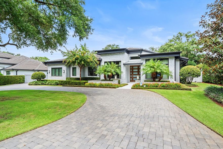 Welcome to this stunning well-appointed home in the highly desirable Via's of Winter Park. This one-level home offers a blend of modern design, luxury and functionality. Nestled on a tree-lined street, this four-bedroom, four-bathroom home with two-half baths is designed for comfort and entertaining. Upon entering you are immersed in 25-foot-high ceilings and greeted by an expansive, light-filled space featuring gorgeous hardwood floors in all main rooms of the home. With custom details throughout, the main living room has custom built-in shelving and a remote-controlled fireplace. The dining room showcases a beautiful, custom wood drop-ceiling feature, elegant chandelier, custom drapes and remote-controlled blinds, plus a show stopping glass-enclosed wine cellar with wine refrigerator and dimmable LED lights. The chef’s kitchen is a culinary masterpiece with extra-tall cabinetry, and has an enclosed coffee station, over and under dimmable lighting, Thermador appliances including a six-burner natural gas range/oven, a second built-in convection oven, microwave, and two full-size dishwashers along with a huge walk-in pantry with custom shelving. The oversized quartzite island features a large sink and room for plenty of seating. A separate breakfast area creates an inviting space for casual dining and entertaining. The primary suite is made extra private by the split plan layout and features an open yet separate 7-by-10-foot flex space for a reading nook, an exercise area, a desk for extra office use or a makeup vanity area. The bedroom with wood floors has a custom wood accent wall with dimmable LED lighting along with the home's signature private outdoor shower. The spacious, open spa-like bath includes separate vanities, tons of storage at each sink, two separate water closets, one with a bidet, a modern soaking tub, and large marble walk-in shower with body sprays. The two extra large walk-in closets with custom built-ins ensure ample wardrobe and storage space. All additional bedrooms are spacious with full en-suite baths and walk-in closets with custom built-ins. The dedicated office offers a large viewing window, wall mounted TV, built-in shelving and cabinets, custom leather-look wallpaper and remote-controlled blinds with custom drapes. The outdoor living space is equally impressive featuring a covered lanai and a full summer kitchen with grill, marble countertops and flooring, an oversized ceiling fan and large screened TV. The pool and spa, controlled by Aqua Link App, provides tranquility and relaxation with a waterfall feature and safety screens. Additional features of the home include a Lutron lighting system with app control, Sonos speaker in all main rooms including outdoor lanai, custom window treatments and custom lighting throughout. The oversized yard is meticulously landscaped and is made extra private by the low-maintenance vinyl fence. The attached oversized two-car garage includes custom shelving and a finished air-conditioned attic for extra storage. This stunning property is ideally just steps from Winter Park Racquet Club and within proximity to the renowned shopping and unique dining options on Park Avenue. With easy access to downtown Orlando, and sporting and entertainment venues, there is also access to Orlando’s International Airport and the area’s famous theme parks. This home, which has too many features to list, offers the best of luxury and convenience.