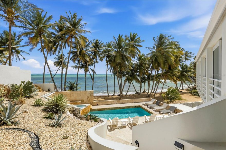 Set along one of Palmas del Mar’s most coveted stretches of coastline, 32 Shell Castle presents a rare opportunity to own a refined oceanfront retreat where contemporary design meets the effortless rhythm of Caribbean living. Positioned directly above the shoreline and framed by a row of swaying palms, the residence captures uninterrupted views of the turquoise waters and the ever-changing horizon beyond. Boasting approximately 5,500 square feet of interior living space on 0.26 acres, the residence is thoughtfully arranged across three levels, offering five ensuite bedrooms, each positioned to capture sweeping ocean views. The primary suite offers a particularly peaceful retreat, opening to its own terrace where mornings begin with the sound of waves and the scent of salt air. Clean architectural lines, warm natural textures, and expansive glass openings define interiors that feel both modern and tranquil, allowing sunlight and coastal breezes to move effortlessly throughout the home. The main living areas embrace a seamless indoor-outdoor lifestyle. A dramatic open-concept great room with soaring ceilings connects effortlessly to the expansive terrace overlooking the Atlantic. The gourmet kitchen, anchored by a generous island and sleek custom cabinetry, flows naturally into the living and dining spaces, creating an ideal setting for entertaining while remaining connected to the spectacular coastal backdrop. Outside, the property continues to impress. A beautifully designed pool terrace sits just above the beachline, creating a resort-style setting for relaxation and gatherings. Multiple terraces and outdoor seating areas allow residents and guests to enjoy different perspectives of the coastline throughout the day, from sunrise reflections across the water to golden Caribbean sunsets. Balancing elegance, comfort, and a true connection to its natural setting, 32 Shell Castle embodies the essence of elevated beachfront living. Located on Puerto Rico’s southeastern coast, Palmas del Mar is one of the island’s most established resort communities. Spanning over 2,700 acres, it offers a rare combination of privacy, natural beauty, and world-class amenities. Residents enjoy access to two championship golf courses, a full-service marina, tennis and pickleball clubs, equestrian facilities, beach clubs, and miles of scenic walking and cycling paths. The community also features a vibrant village center with restaurants, cafes, boutiques, everyday conveniences, and a school creating a self-contained coastal lifestyle just minutes from the water. Despite its tranquil atmosphere, Palmas del Mar remains conveniently located about 45 minutes from San Juan and Luis Munoz Marin International Airport, making it easily accessible for both primary residents and seasonal homeowners.