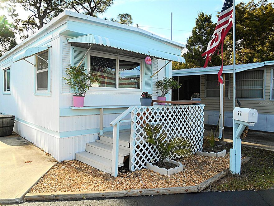 This is a fantastic opportunity to own a 2 bedroom/ 2 bath mobile home in Eagles Nest Mobile Home Park at an AFFORDABLE price and a LOW monthly HOA fee of only $177/month! Eagles Nest is a 55+ cooperative park located in a FANTASTIC LOCATION-  just 10 minutes from the Gulf Beaches and across from the 133 acre Walter Fuller Park, which offers walking & fitness trails, a swimming pool, basketball, baseball, tennis/ pickleball courts, and hosts many sporting events and festivals.  Also nearby are numerous restaurants, a plethora of shopping options, the Tyrone Square Mall, a movie theatre, and the VA hospital, just to name a few.  The monthly fee includes water, sewer, trash and lawn maintenance and the park welcomes two (2)  furry friends (dog an/or cat) up to 30 lbs. each.  This may be the time for you to own a piece of paradise as a vacation home or an affordable primary residence. The home has NEW vinyl plank flooring in the living room, NEW carpet in the bedrooms, NEW windows and a NEW hot water heater.  You can enjoy an open living room, dining room/ kitchen area, split bedrooms and central HVAC.  This is one of just a few lots that provides a new wooden deck in the backyard- a perfect spot for relaxing under the pine trees. Currently there are 2 parking spaces and the option to add an enclosed screen room with washer/ dryer hook up and a carport, if you'd like. Hurry and see this today!