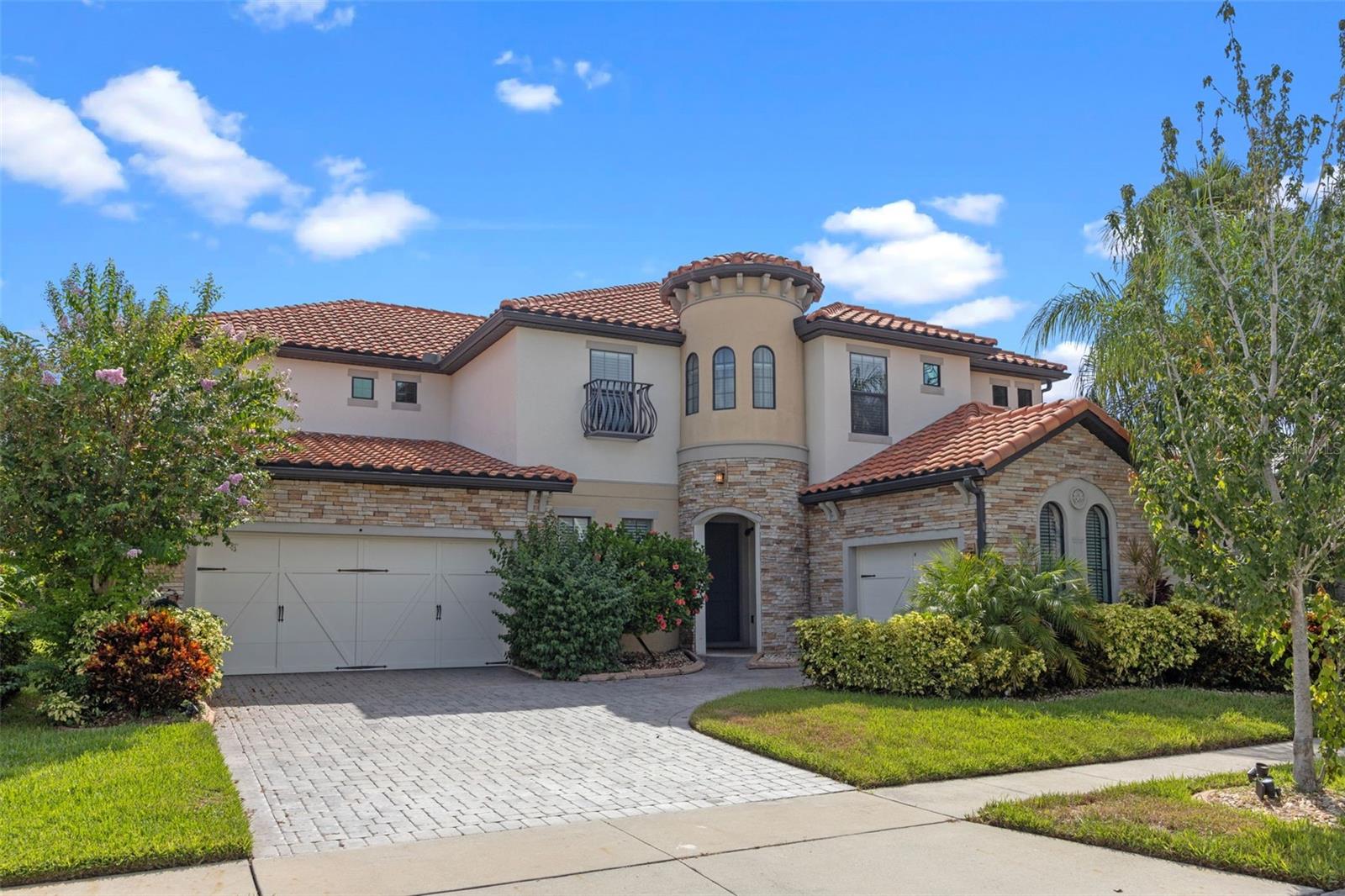 Step into unparalleled luxury at 3844 Bowfin Trail, a true Mediterranean masterpiece in Bellalago Community. Spanning 5,280 sq ft, this custom “mini-mansion” boasts six bedrooms, a dedicated theatre room, private office/den and an expansive loft that opens to a balcony overlooking your resort-style pool and spa. From the moment you arrive, you’ll be greeted by meticulously landscaped grounds, elegant pavers and a Spanish-Mediterranean tile roof accented with a charming Romeo & Juliet balcony. Inside, soaring ceilings, 8-ft solid-core doors, designer light fixtures and a sweeping wood-and-spindle stairway create an immediate sense of grandeur.
The gourmet kitchen features granite countertops, stainless-steel appliances, custom cabinetry and an oversized island ideal for casual meals or cocktail parties. Step through French doors onto the over-extended screened lanai, complete with a built-in outdoor kitchen, ambient lighting and panoramic views of the conservation-backed backyard—perfect for summer soirées or quiet morning coffees.
Live like you’re on vacation every day with Bellalago’s 24-hour guard-gated security, championship-style pool, water-park slides, fitness center, lakeside fishing piers and “Flip Flops” poolside bar. All this just 35 minutes from Walt Disney World, Universal Orlando and Central Florida’s top attractions.