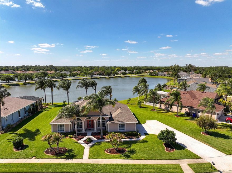 Built by Americas Homes, this truly exceptional 4-bedroom, 3-bath pool home is situated on .39 acres, showcasing quality craftsmanship and thoughtful design. From the moment you arrive, the beautifully manicured landscaping, extra-long and wide paver driveway, paver walkway, and a striking leaded glass entry door set the tone for what awaits inside. Step into a light-filled interior where architectural details take center stage. Elegant archways, decorative columns, crown molding, and niches complement the soaring vaulted ceilings, while warm designer tones create an open feel and add timeless character. Rich hardwood flooring transitions seamlessly to ceramic tile offering style and durability throughout the main living and wet areas. The open floor plan is both inviting and functional, complemented by a formal dining room, a private office with French doors, along with a split-bedroom design for added privacy. The spacious primary suite is a relaxing retreat, complete with a tray ceiling, two closets including a walk-in, a light-filled sitting area, and sliding doors that open to the lanai with tranquil pond views. The ensuite bath offers dual sinks, a stone-top vanity, garden tub, and a separate tiled shower. Two additional bedrooms share a full bath, while the fourth bedroom is tucked away in a three-way split featuring its own full bath and direct pool access. It is a perfect layout for guests or extended living. At the heart of the home, the kitchen features solid wood cabinetry with 42" uppers, hardware and crown molding, a cabinet pantry, stunning backsplash, granite countertops, stainless steel appliances, and generous counter space. A separate dinette and breakfast bar are ideal for casual meals, and this entire space opens to the living area which captures amazing views of the outdoor oasis. Sliding doors lead to your private outdoor setting, featuring an expansive screened lanai and saltwater heated pool. A separate seating area captures the sweeping pond view and breathtaking sunsets. Pride of ownership is evident with numerous upgrades, including: refurbished 8-zone irrigation system (2026), Rheem ProTerra performance 65-gallon heat pump water heater (2025), 3-zone HVAC system (2020), roof, gutters, and upgraded ventilation system (2020), energy-efficient GE washer and dryer (2020), salt system pool conversion (2023), Pentair SuperFlow variable speed pool pump, Pentair UltraTemp heat pump, and multi-color lanai lighting with remote. Ideally located just minutes from the Florida Turnpike, with convenient access to shopping, dining, and daily conveniences. This home offers a rare blend of comfort and style, and won't last!