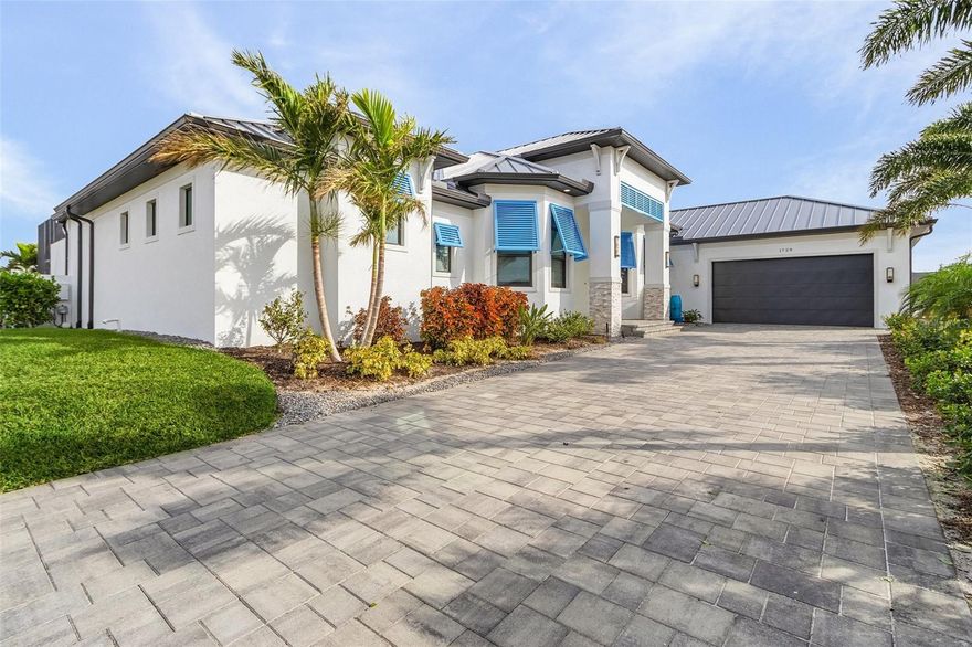 This 2023 custom-built masterpiece redefines luxury living, blending luxury design with exceptional functionality. Boasting over 3,000 square feet of meticulously crafted space, this home offers unparalleled features that cater to both comfort and style. Situated on a rare lot with direct Gulf access, the property is surrounded by water on two sides, providing breathtaking views and the ultimate waterfront lifestyle. As you step through the front door, you're immediately greeted by exquisite porcelain tile flooring that flows seamlessly throughout the open-concept living areas. The spacious living room, featuring an electric fireplace, is perfect for cozy nights in, while the two sets of 90-inch sliders open to the outdoors, enhancing the home’s connection with nature. The heart of the home is the chef’s kitchen, equipped with high-end appliances, including an induction cooktop, double oven, and a wine refrigerator. A large walk-in pantry provides ample storage, while the sleek countertops and custom cabinetry offer both beauty and practicality. The adjacent dining area is perfect for entertaining, with plenty of space for large gatherings. This home offers two luxurious master suites, each with their own spa-like bathrooms. The primary suite is a true retreat, featuring a walk-through shower with dual shower heads and an elegant dual vanity. The second suite is equally impressive, offering ample space and comfort for guests or family. Both suites boast large closets with custom built-ins for maximum organization. The non-conforming 3rd Bedroom is being used as an exercise room. The flexible floor plan also includes a dedicated office, perfect for remote work or a quiet retreat. Additional highlights include 2.5 baths with modern fixtures, a laundry room complete with cabinets and a sink, and a 2.5-car garage with an electric car charger and cable for added convenience. The whole home is equipped with a top-of-the-line alarm system and surround sound, ensuring both security and entertainment. The outdoor space is where this home truly shines. Step outside to your own private oasis featuring a custom-designed pool with vibrant light features and cascading waterfalls. The adjacent hot tub with a vanishing edge offers the perfect place to relax while taking in the stunning water views. This rare find offers direct Gulf access with unparalleled views and outdoor living, all within a thoughtfully designed custom home that seamlessly blends luxury, comfort, and cutting-edge technology. With its exceptional features and unique location, this home is truly one of a kind.