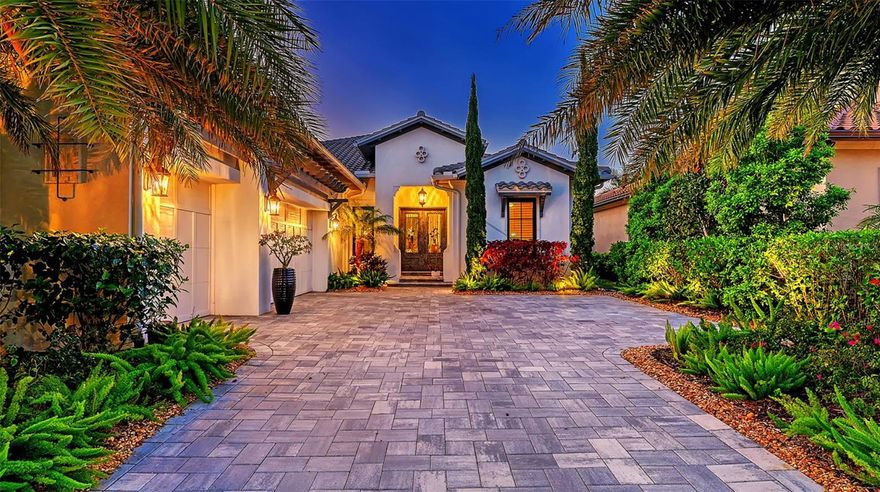 Set within the prestigious Matera neighborhood of The Lake Club, this green-certified Wetherington residence showcases refined design and quality in a 2021-built home created for both everyday comfort and effortless entertaining. A striking pair of handcrafted iron doors welcomes you into a light-filled interior featuring porcelain tile flooring, plantation shutters, tall crown molding, designer lighting, and distinctive square LED recessed fixtures. * * * 
The great room makes a dramatic impression with a cypress-beam coffered ceiling and shiplap accent wall, while pocketing sliders open the space seamlessly to the outdoors. A dedicated office or den with double doors provides a quiet, flexible retreat. * * * 
Outdoor living takes center stage on the expansive travertine lanai, where a heated saltwater pool and spa are complemented by a fully equipped outdoor kitchen with stainless grill and beverage cooler—ideal for relaxed gatherings or elegant evenings under the stars. * * *
The chef’s kitchen is both beautiful and functional, featuring GE Monogram appliances, quartz countertops, crisp white cabinetry, mosaic glass tile, a spacious center island with seating, and a concealed walk-in pantry. The dining area enjoys tranquil views of the lanai and landscaping beyond. * * * 
The primary suite offers a serene escape with a tray ceiling and oversized windows, while the spa-inspired bath features a freestanding soaking tub, walk-in shower, quartz surfaces, and shiplap detailing. Two additional guest suites, each with a private bath and custom closets, are thoughtfully positioned for privacy. Additional highlights include a generously sized laundry room, Wetherington’s signature “Florida Basement” for extra storage, and a three-car side-entry garage with epoxy flooring. * * *
Matera residents enjoy maintenance-free living, with the HOA covering landscaping, irrigation, AND pool care. The Lake Club’s resort-style amenities include an elegant clubhouse, dining, two resort pools, tennis courts, fitness center, scenic walking trails, and a network of lakes perfect for kayaking and fishing.