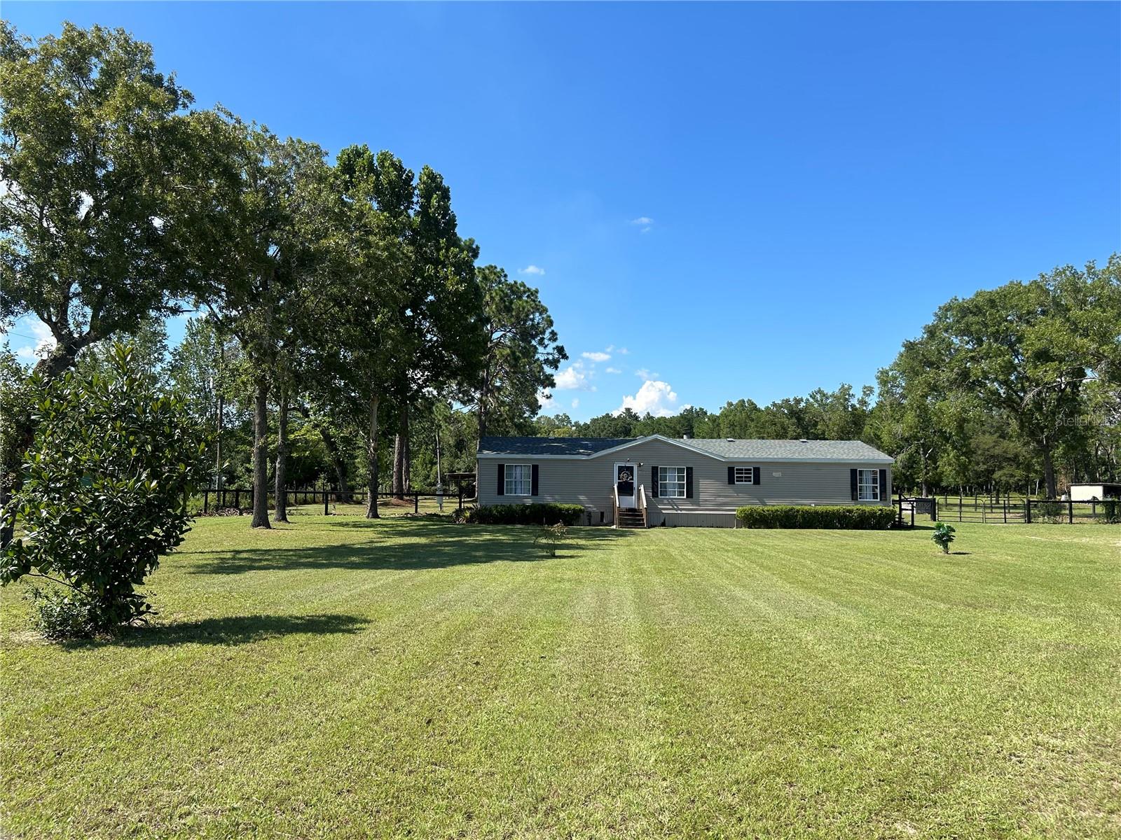 Come check this out! 2.41 acres on a paved road, with a fantastic location just 10 minutes south of the World Equestrian Center (WEC)!! This property is zoned agriculture (A1) and no HOA. This spacious four bedroom two bath home is a split plan.The primary suite is privately located on one side of the home while the other three bedrooms are on the opposite side offering great privacy, perfect for family living. Luxury vinyl plank flooring flows throughout the main living spaces while the bedrooms have carpeting for added comfort. On those welcoming colder nights here in Ocala this home has a beautiful wood-burning fireplace to enjoy. Perfect for those movie nights or gatherings with friends and family.
The 2.41 acre lot that is completely perimeter fenced plus cross fenced offers endless possibilities. Whether you’re dreaming of starting a garden, raising animals, building a workshop or just enjoying the extra space and privacy this property gives you the freedom to do it all. You’ll have the flexibility to truly make it your own.
This is a must see!!
Schedule your private tour today.