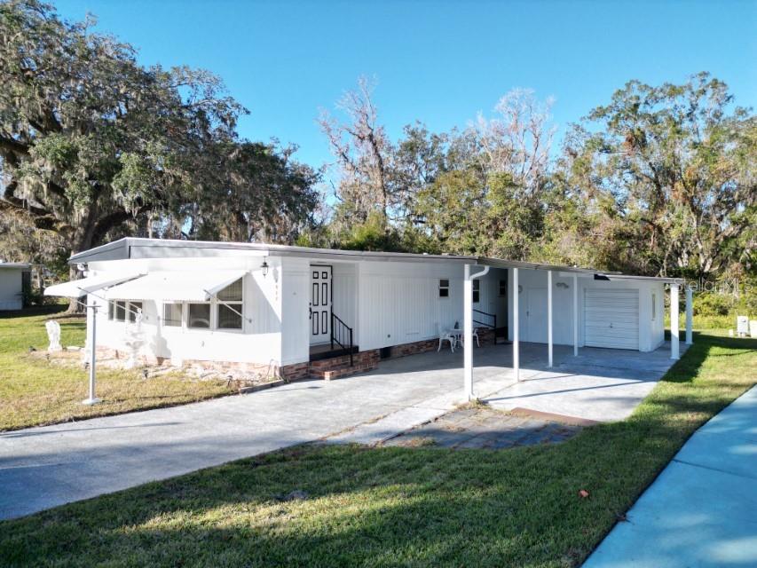 TRAVELER'S REST RESORT - DADE CITY FLORIDA - This recently renovated 2-bedroom and 2-full bath home has so much to offer. You will find fresh interior/exterior paint, new shower stall in the primary bathroom, and a new tub in the second bathroom. A large formal living room and an even larger family room with access to a beautiful side porch. Ample closet space in the primary bedroom with laundry closet in the primary bathroom. New vinyl laminate in all wet areas and throughout the rest of this beautiful home you will find new carpet. This home includes an enclosed lanai, workshop, and a golf cart garage. Included in this sale is a RV parking pad with 30amp & water hookups next to the 2-car carport. This setup is perfect for the traveler or a full time Florida resident who wants to apply for homestead exemption. This resort offers a 9-hole golf course, community swimming pool, hot tub, a library, hobby center, walking paths, a game room for billiards darts, covered shuffleboard courts, tennis and pickleball courts, Bocce, Bingo and so much more. Not many of these homes come on the market and when they do it is who you know. Well, you know me. Call today to see this great find that will not last long.
