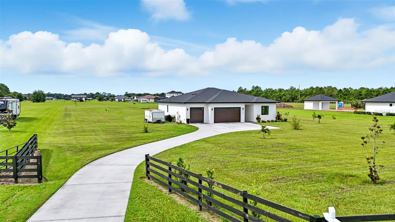 Welcome to Your Lakefront Oasis at 4440 E Shirley Shores Rd in Tavares. This beautifully designed 3-bedroom, 2-bathroom home, built in 2023, sits on 2 acres and combines modern comfort with exceptional waterfront living. The home features a 3-car garage, soaring 10-foot ceilings, and tile flooring throughout. Every bedroom is equipped with remote-control ceiling fans, and there is a dedicated indoor laundry room for convenience. The gourmet kitchen is a showpiece, offering an induction cooktop, farmhouse sink, large island with breakfast bar, abundant storage, and stainless steel appliances—perfect for everyday living and entertaining. Located on a canal with direct access to the Harris Chain of Lakes, this property allows you to launch your boat from the private community ramp and enjoy over 75,000 acres of interconnected waterways, including Lake Harris, Lake Eustis, and Lake Dora. Just minutes from downtown Mount Dora and close to downtown Tavares’s waterfront restaurants, this home offers the perfect blend of rural tranquility and urban convenience, all within an hour of Orlando’s world-class attractions and airport. To complete the setting, the property is enhanced with a variety of tropical fruit trees—mango, lychee, june plum, sugar apple, jackfruit, persimmon, lemon, and more—creating your own private backyard paradise.