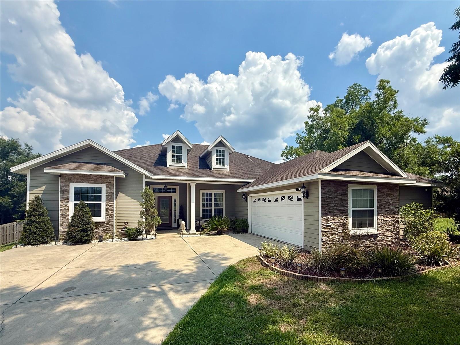 Your next home is nestled in a serene cul-de-sac within the sought-after gated community of Wyndswept Hills! This stunning 2014 build features 4 bedrooms and 3 bathrooms in a 3-way split open floor plan. The open design seamlessly connects the living, dining, and kitchen areas, creating a warm and inviting atmosphere. The kitchen boasts elegant granite countertops and modern stainless appliances, making it a delight to cook or entertain in. The stylish crown molding and engineered hardwood floors are highlighted by the abundance of natural light. Celebrate the holidays with elegance in the formal dining space, or comfortably in the open kitchen. The luxurious, spa-like master bathroom boasts split vanities, double walk-in closets, a jetted tub, and separate shower. Situated on a generous half-acre lot, the large fenced backyard is perfect for outdoor gatherings, playtime, or simply enjoying the peaceful surroundings. With Main Street Alachua just steps away, you’ll have easy access to local shops and dining. Plus, a short drive in one direction brings you to Gainesville for even more entertainment and amenities, or jaunt off to the springs and spend the day in nature. Don't miss this opportunity to own a beautiful home that combines comfort, style, and convenience! Schedule your tour today!