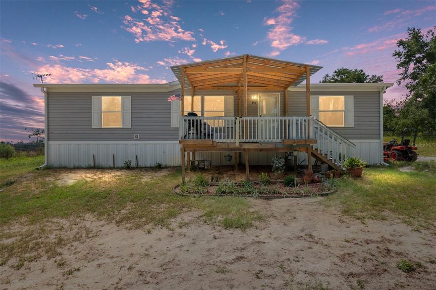 Beautiful, LIKE NEW (2024) energy-efficient 3/2 mobile home on 4.08 acres!  Just under 1300 square feet.  No carpet - LVP flooring throughout.  Smart thermostat.  Upgraded, ENERGY-EFFICIENT appliances.  Oven has regular, convection, and air fry capability.  Side by side refrigerator has inside water dispenser and large freezer drawer on the bottom with icemaker.  Washer/Dryer included.  Relax on the large covered 10x14 front porch - sip your coffee and watch the wildlife - deer, turkey, etc!  Includes 4 solar-powered owner-mounted outside cameras.  Small fenced area in back for pets.  Zoned agriculture - plenty of room for animals and garden - perfect for a homestead!  Includes 14x14 shed.  Home has solar panel capability.  Water filtration system at well.  Seller was in process of installing irrigation system, will leave just under 300' of Sharkbite Plex B and all fixings to complete the project.  Transferrable warranty.  Enjoy the tranquility of living in the country but still having the convenience of Gainesville (approx 20 miles) and Ocala (approx 30 miles) close by!  Qualifies for USDA financing!   Boundary lines in aerial photo are approximate.