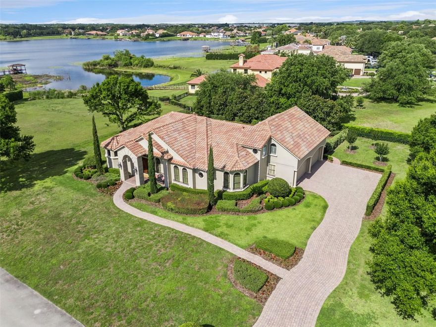 Pro Pics coming but dont wait.  
Opportunities like this are extremely rare. This stunning custom-built Anthony Laux estate sits on a full acre in the private enclave of Lake Davis Estates in Windermere. Tucked away on a private street with just seven custom homes and no HOA fees, it offers privacy and tranquility while remaining minutes from everything that matters.
The home greets you with impressive curb appeal, a long driveway, and a FOUR CAR garage. Ornate double entry solid wood doors open to soaring coffered ceilings and a formal living room anchored by a stone-encased gas fireplace, offering immediate views of the sparkling pool and expansive backyard. The formal dining room features exquisite architectural ceiling details, creating an elegant setting for memorable gatherings.
The kitchen is a chef’s dream with custom cabinetry, a large prep island, Wolf gas cooktop with a true vented hood, a full-size wall refrigerator, and a walk-in pantry. The adjacent dinette overlooks the pool, making everyday meals feel special. This space flows seamlessly into the oversized family room, perfect for relaxing with family or entertaining friends.
Designed for true one-story living, four of the five bedrooms are on the main level. The luxurious primary suite includes a generous custom walk-in closet, garden bath with dual vanities, and a spacious shower. A standout feature is the large rear bedroom with its own full bath and private exterior entrance—ideal as an IN-LAW SUITE—overlooking the pool and Lake Davis. Two additional bedrooms share a convenient Jack-and-Jill bath, completing the thoughtful and functional first-floor layout.
Up the travertine staircase, the second floor offers a private retreat with a large bonus room, full bath, and bedroom—perfect for guests, a home office, or a teenager’s sanctuary. 
Throughout the home, rich wood flooring, meticulously laid travertine,detailed custom trim and casings, and elevated architectural ceiling work creates a luxurious feel. Outside, Florida living shines on the expansive covered lanai with remote screens and a well-equipped summer kitchen overlooking the large pool and large backyard. Breathtaking views of Lake Davis, spectacular sunsets, and even Disney fireworks in the evening add daily magic. An irrigation well keeps watering costs extremely low on the full-acre grounds.
Sought after K-12 schools... Windermere Elementary, Bridgewater Middle, and Windermere High. Windermere Preparatory and Foundation Academy campuses being so close is another huge plus for those with school age family members. Shopping, dining, and entertainment options abound within minutes in every direction, including Dr. Phillips Restaurant Row, Downtown Winter Garden, and Disney just under 20 minutes away. Easy access to the 429 and Florida Turnpike makes commuting effortless.
With a tile roof, four-car garage, private in-law suite, summer kitchen, bonus room, pool, and no HOA on a full acre, this estate offers exceptional value. Homes of this caliber and scale rarely become available—don’t miss your chance to make it yours.